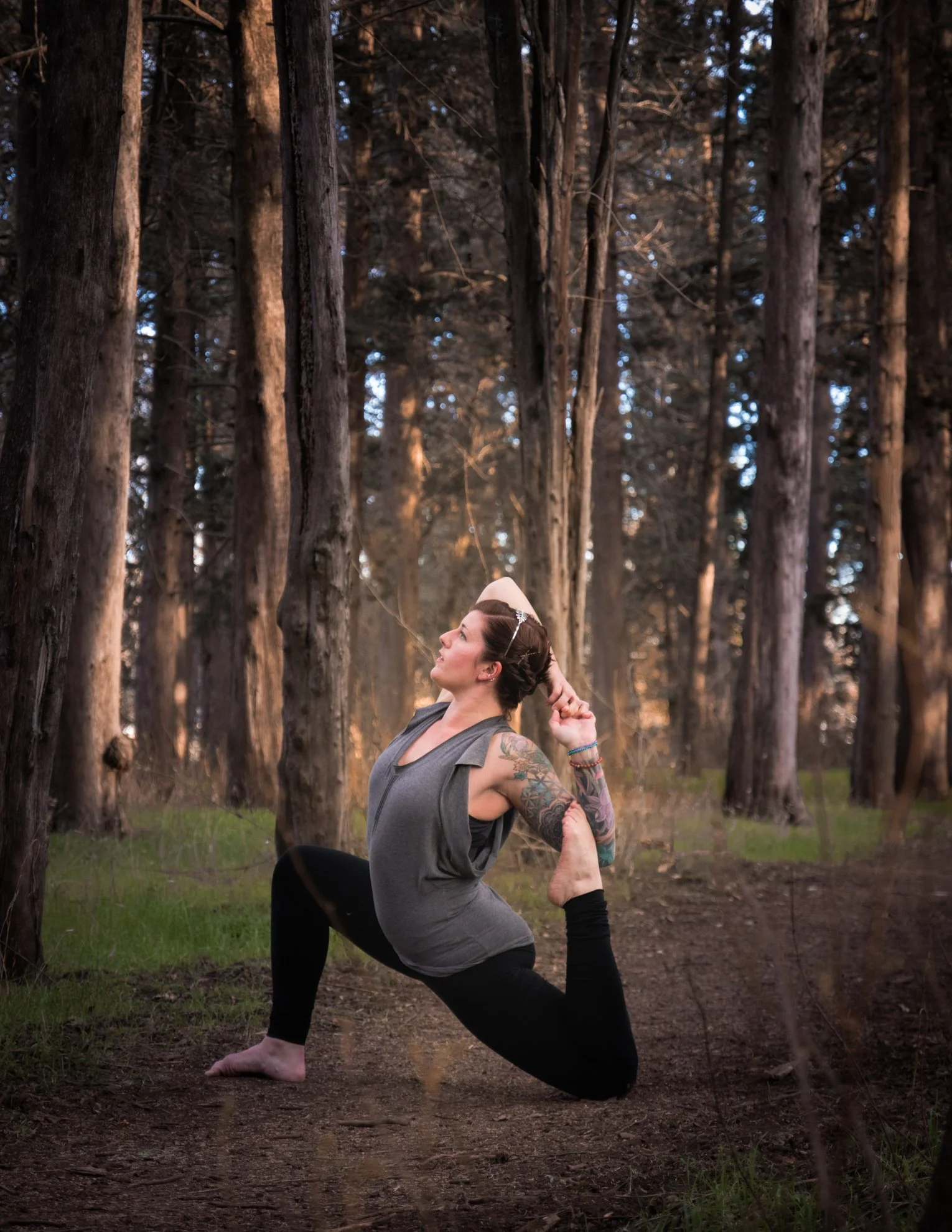 Rachel Warmath doing a yoga pose with a forest in the background