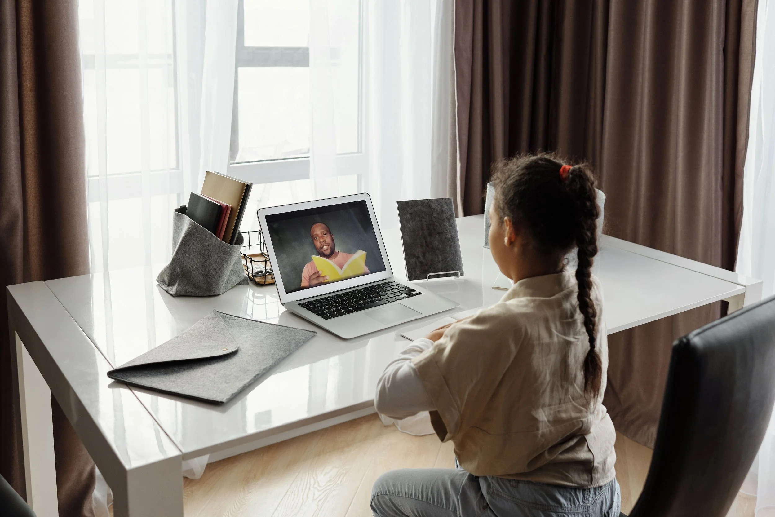 A virtual school student meets with their teacher online