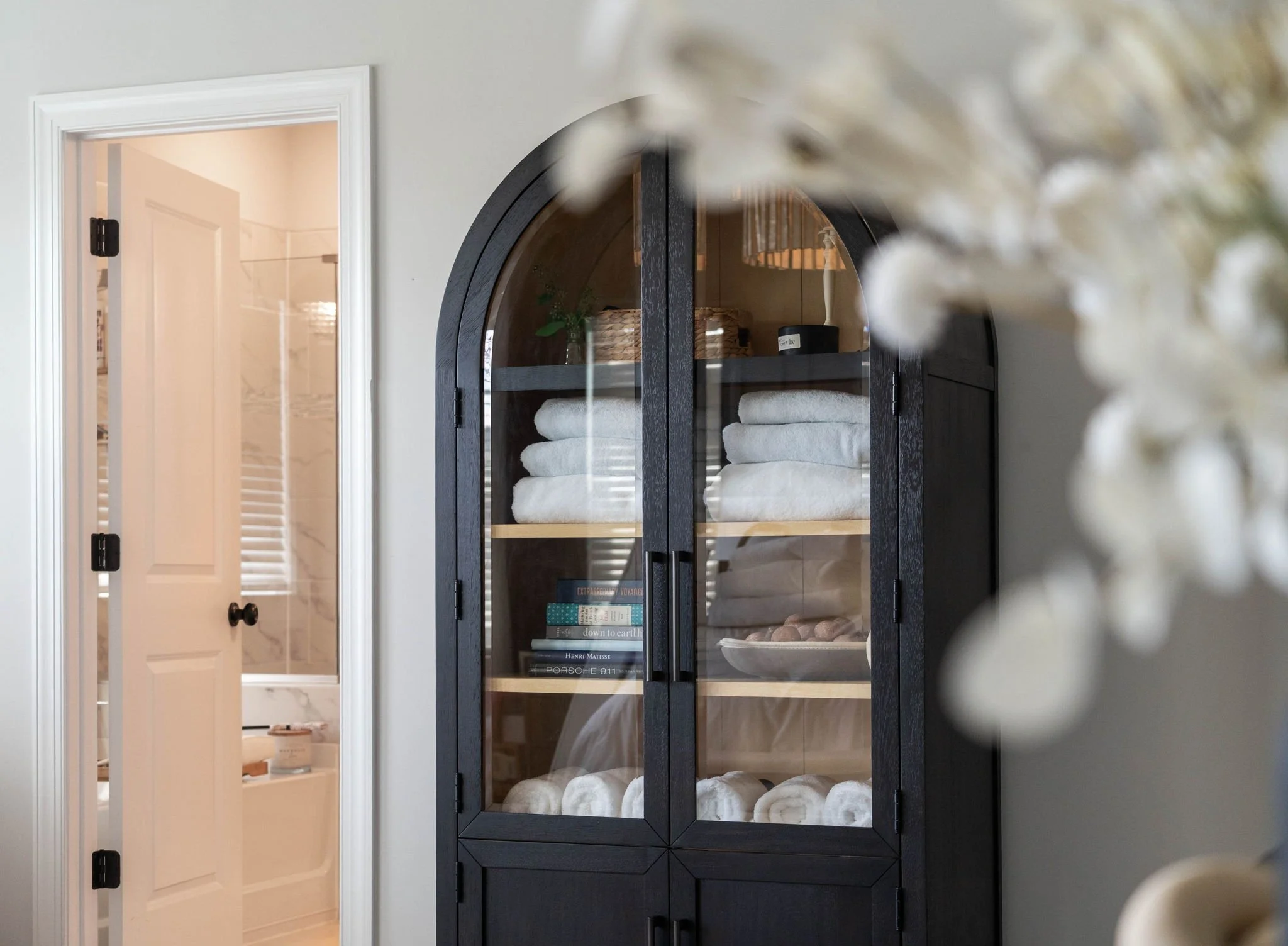 Walk-in closet with shelves of shoes on the right, hanging clothes in the middle, and jewelry and bags on the left.
