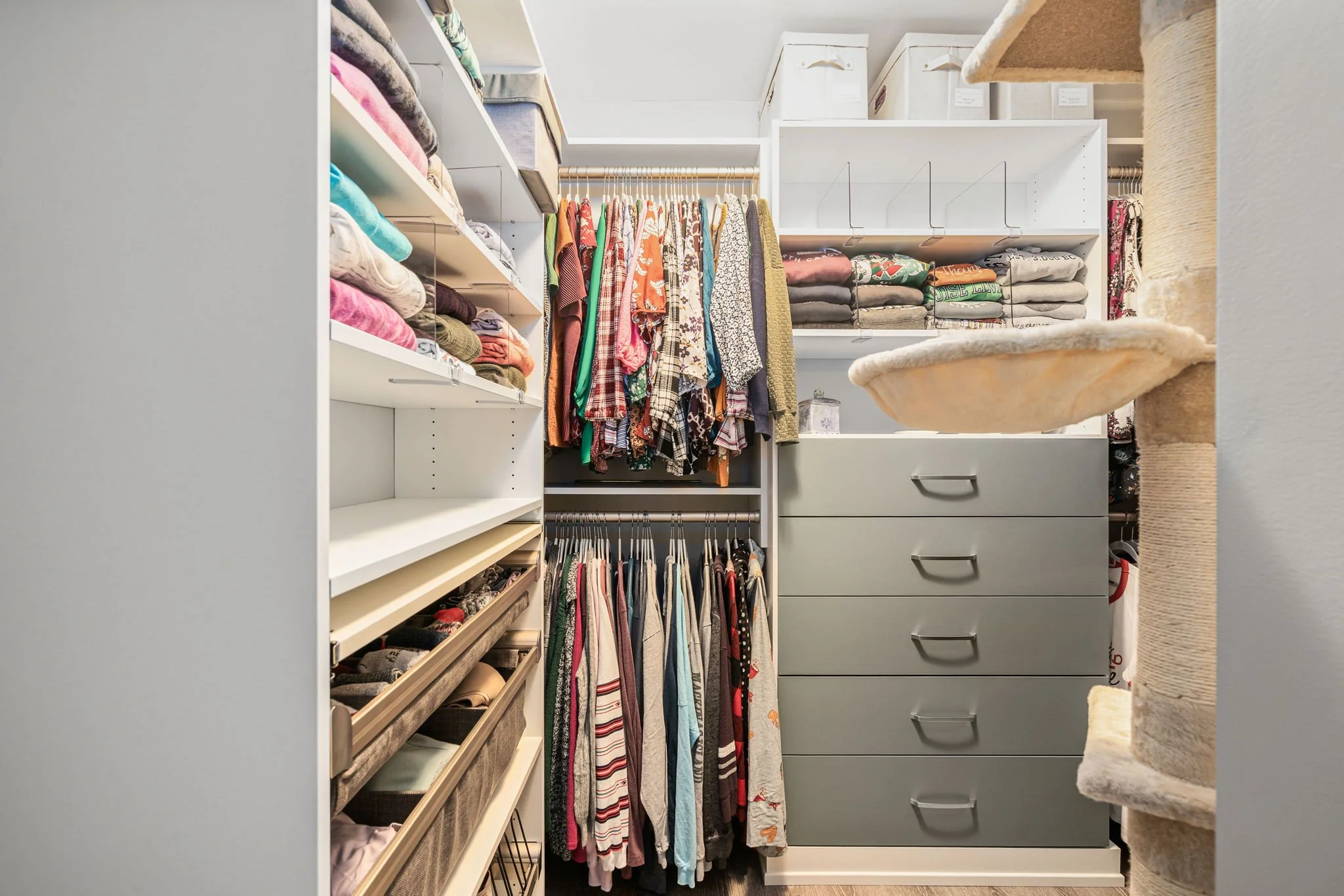 Closet with green drawers and white shelving