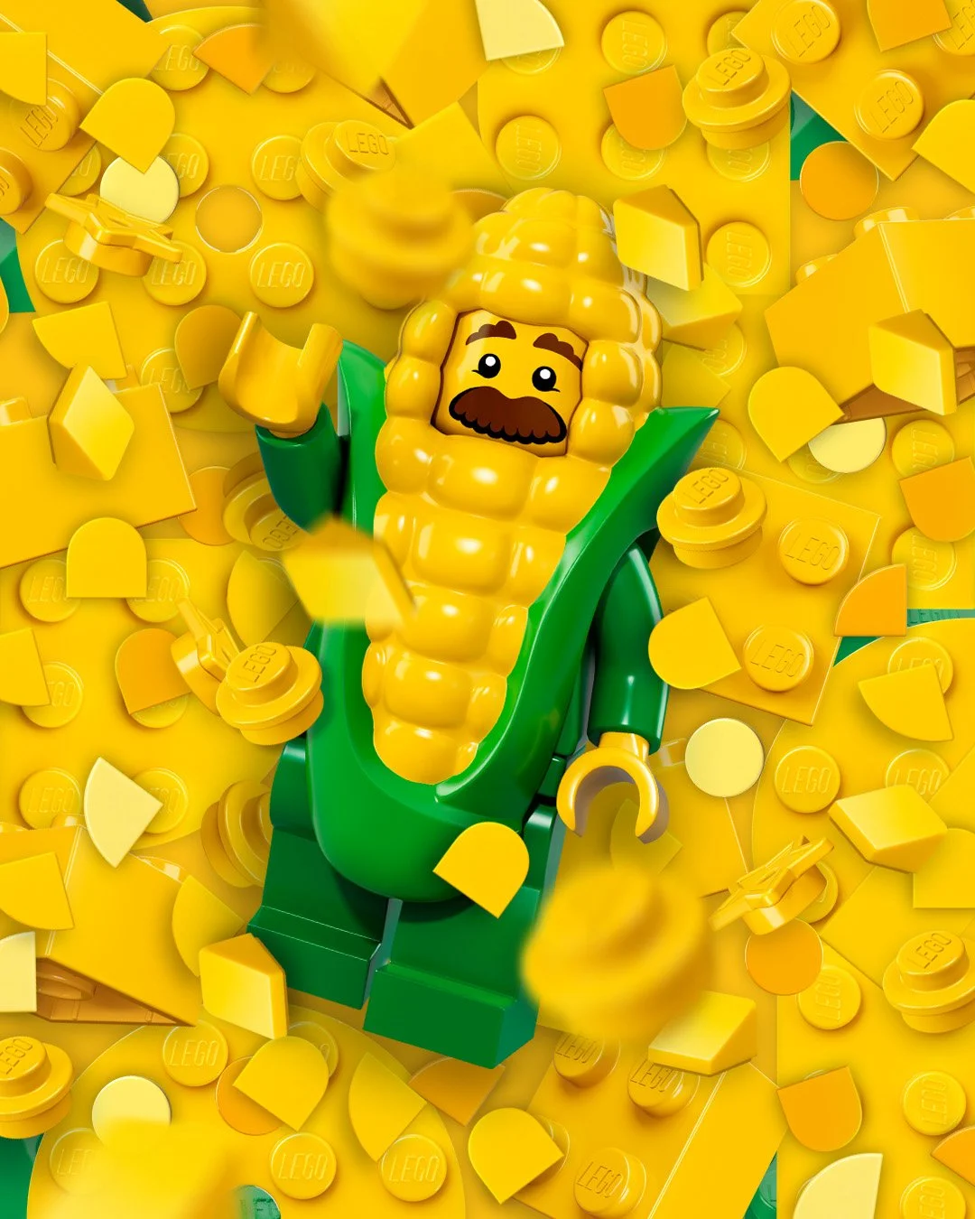 Lego illustration of a corny anthropomorphic corn cob with a mustache, wearing green pants and a green shirt, amidst scattered yellow Lego pieces.