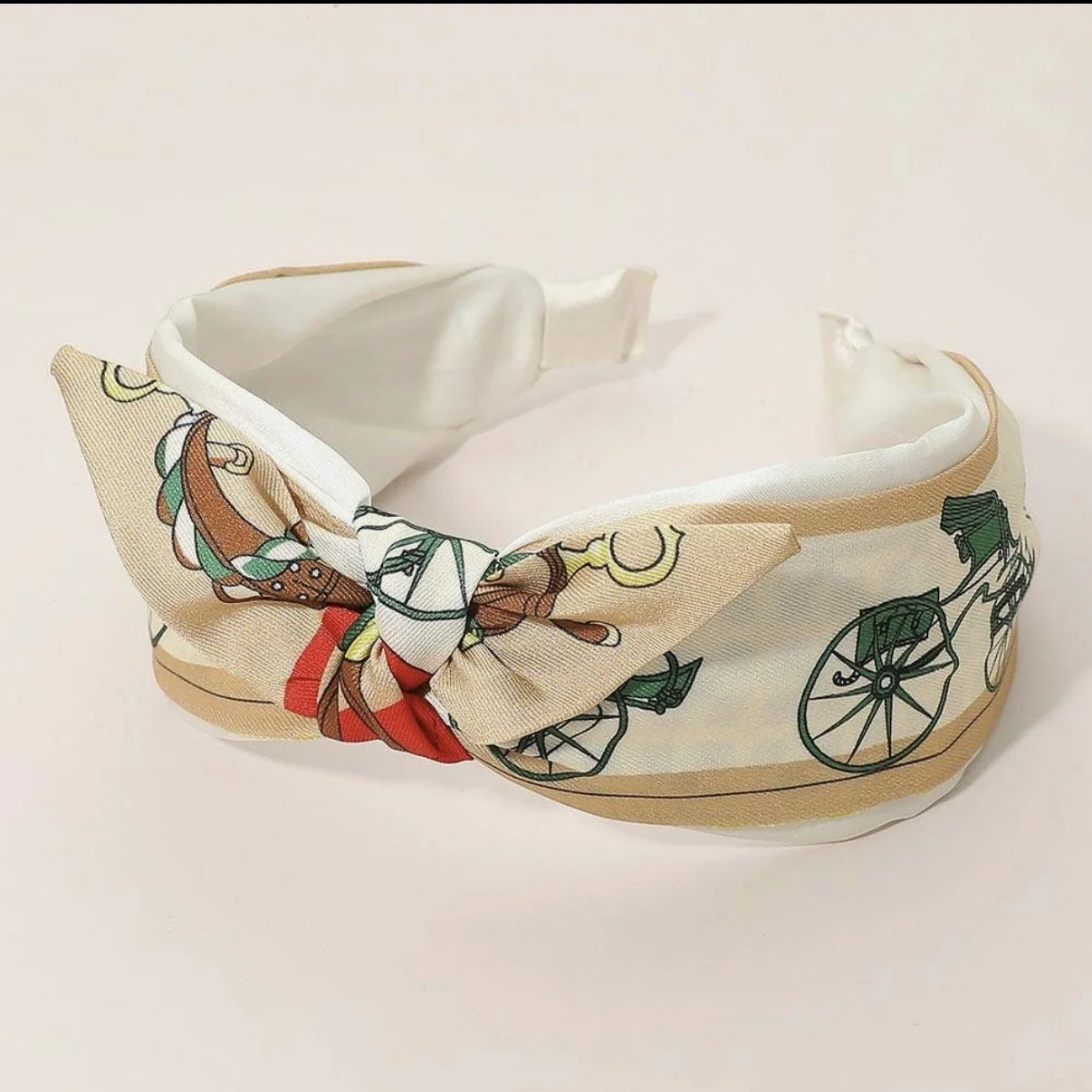 Beige equestrian knotted headband featuring a horse carriage print.