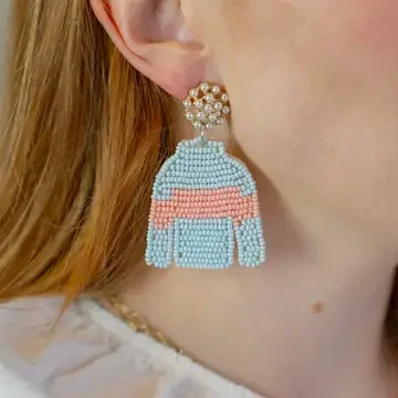 Woman wearing light blue and pink beaded jockey silk earrings