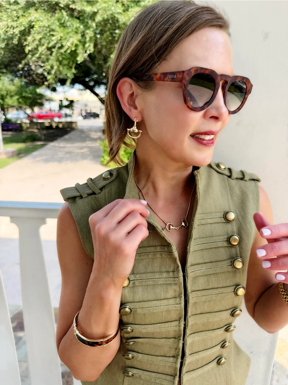 Gold snaffle bit earrings styled on model