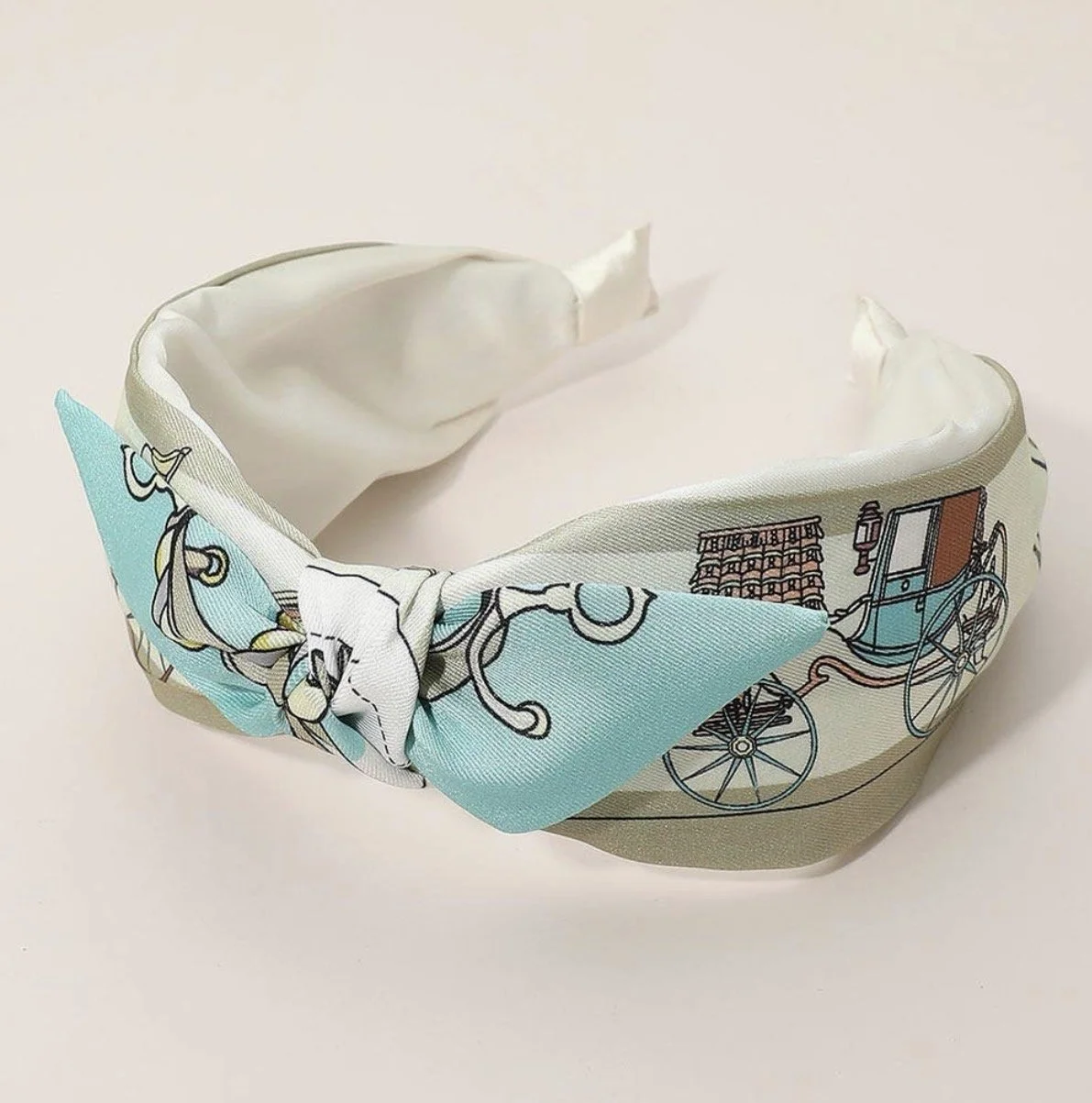 Blue equestrian knotted headband featuring a horse carriage print.