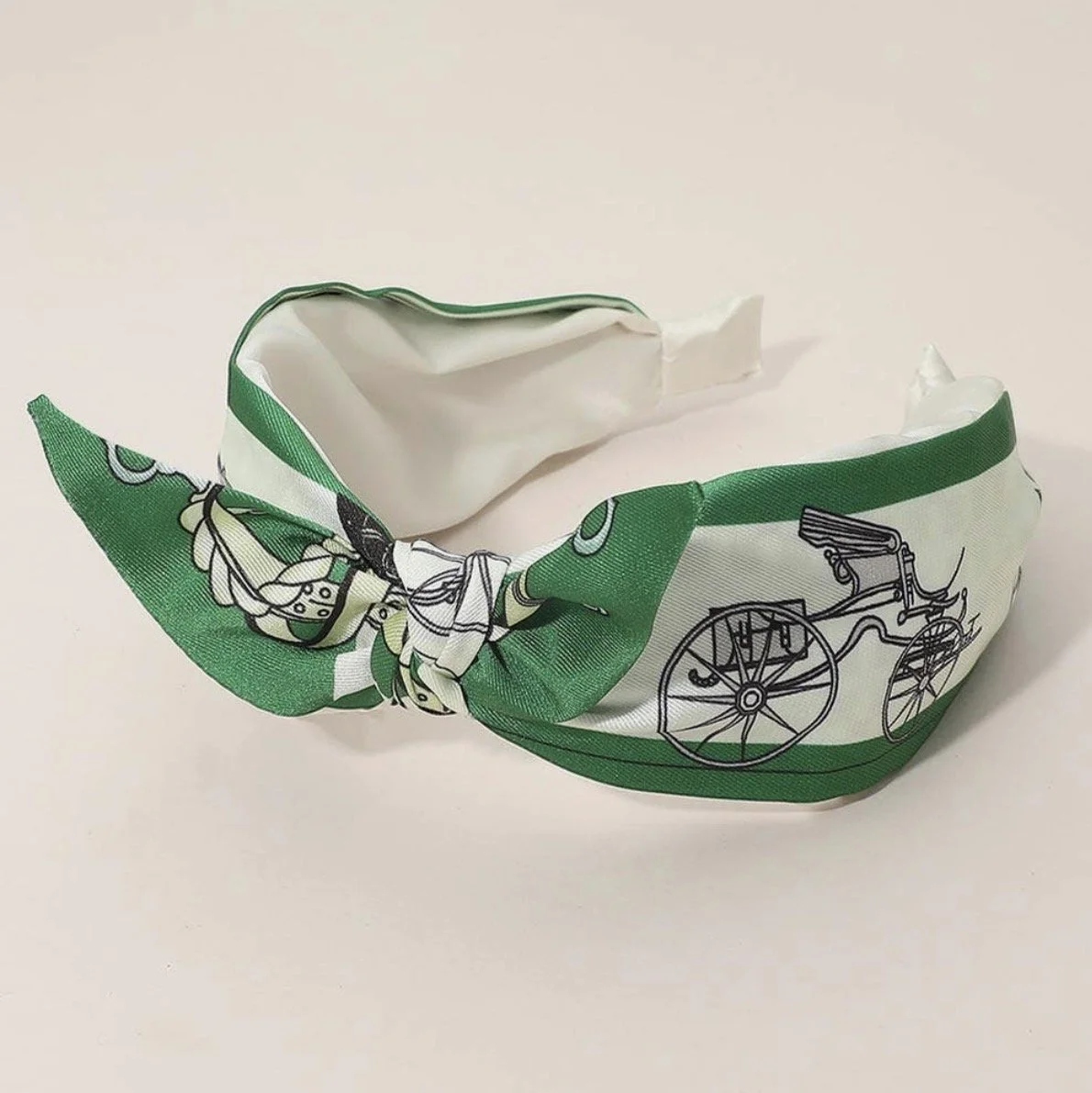 Green equestrian knotted headband featuring a horse carriage print.