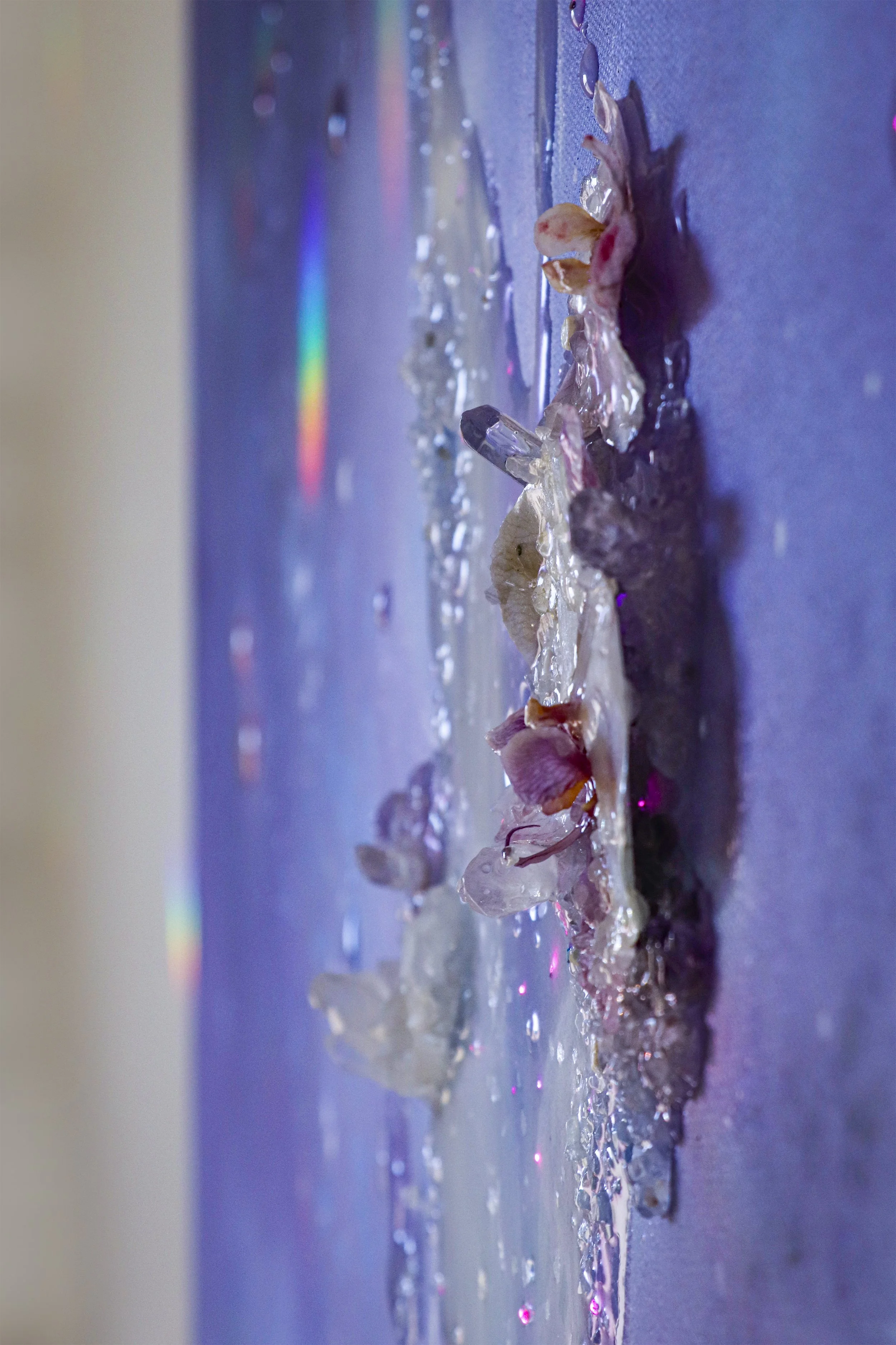 side view, close up detail photo of purple orchids and crystal quartz