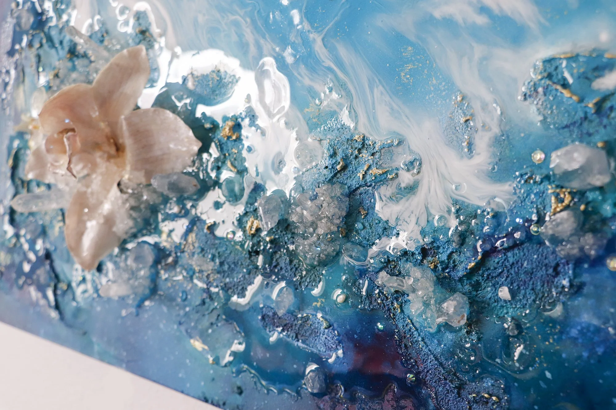 Close up detail photo of textured art with preserved orchid botanical and clear quartz crystals