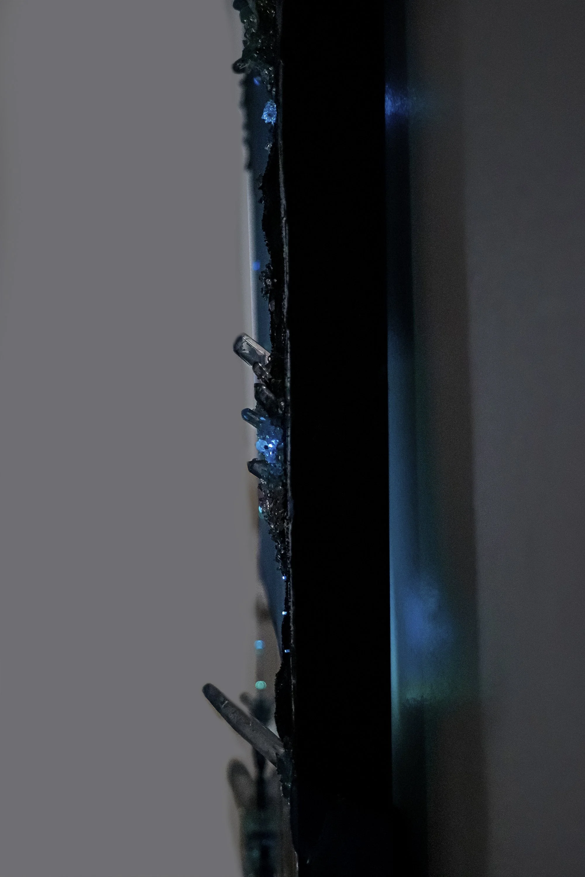side view of blue abstract wall art, with crystals glowing from LED lighting