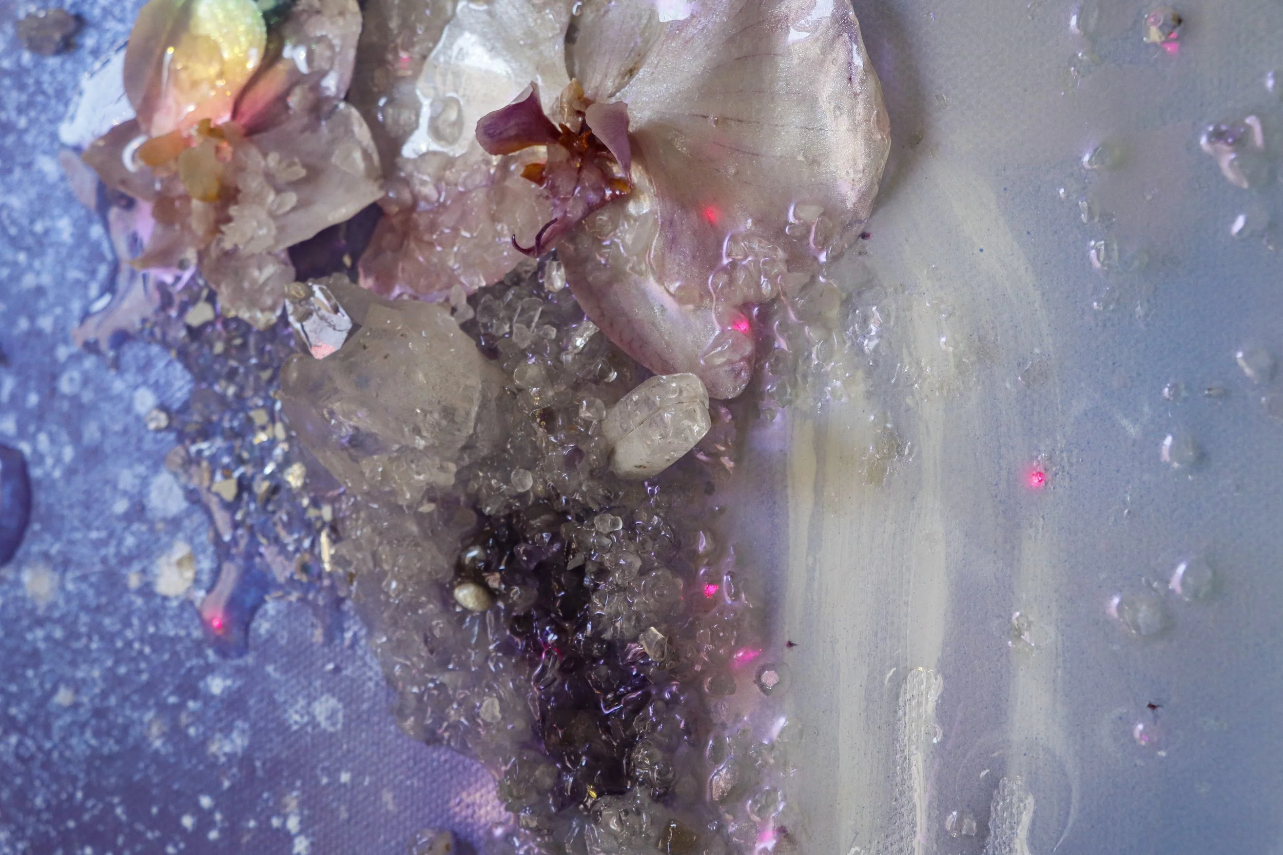 close up detail photo of purple and white orchid with glowing light, quartz and amethyst crystals