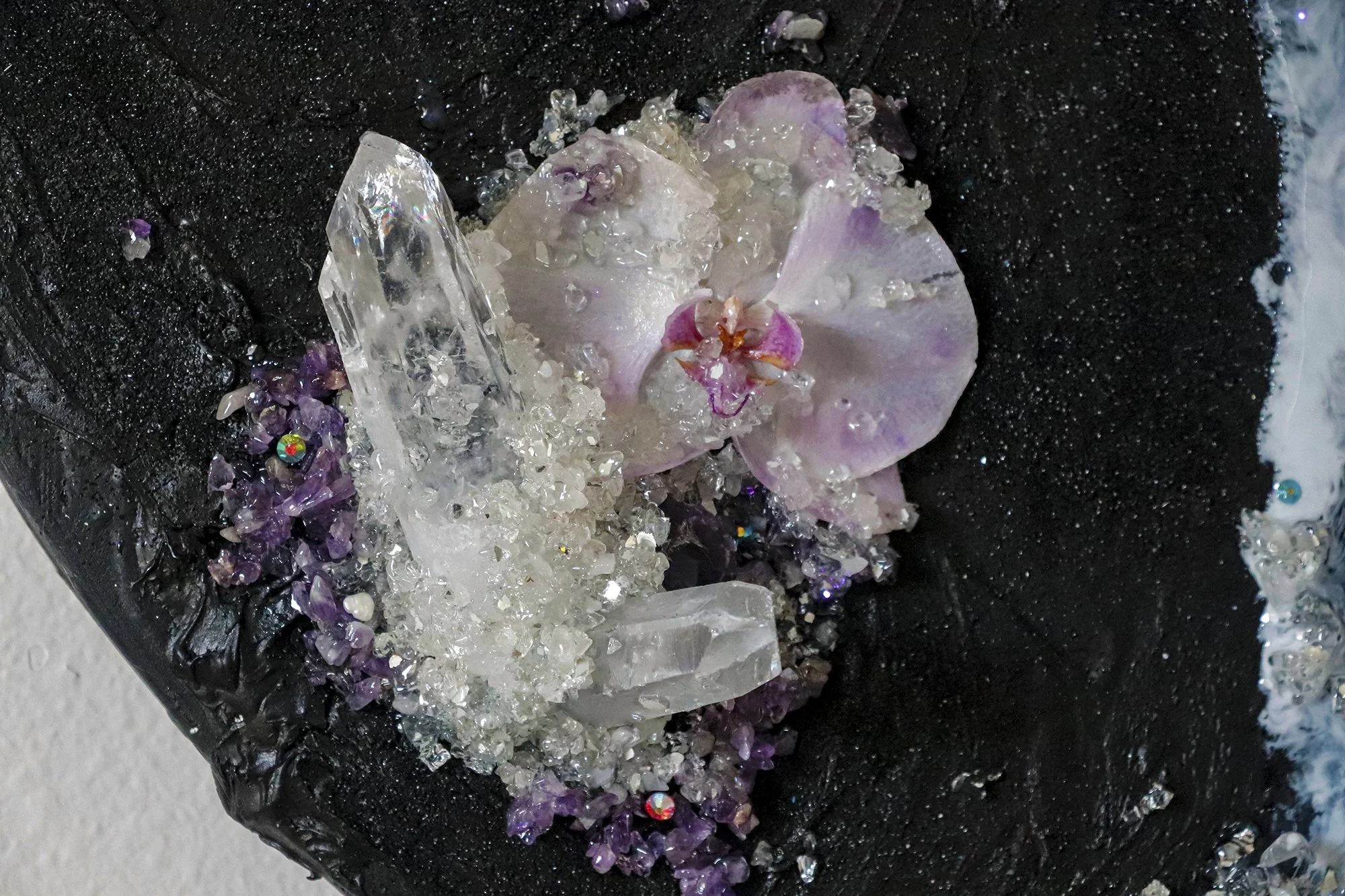 close up detail photo of orchid botanical with large quartz point and cluster