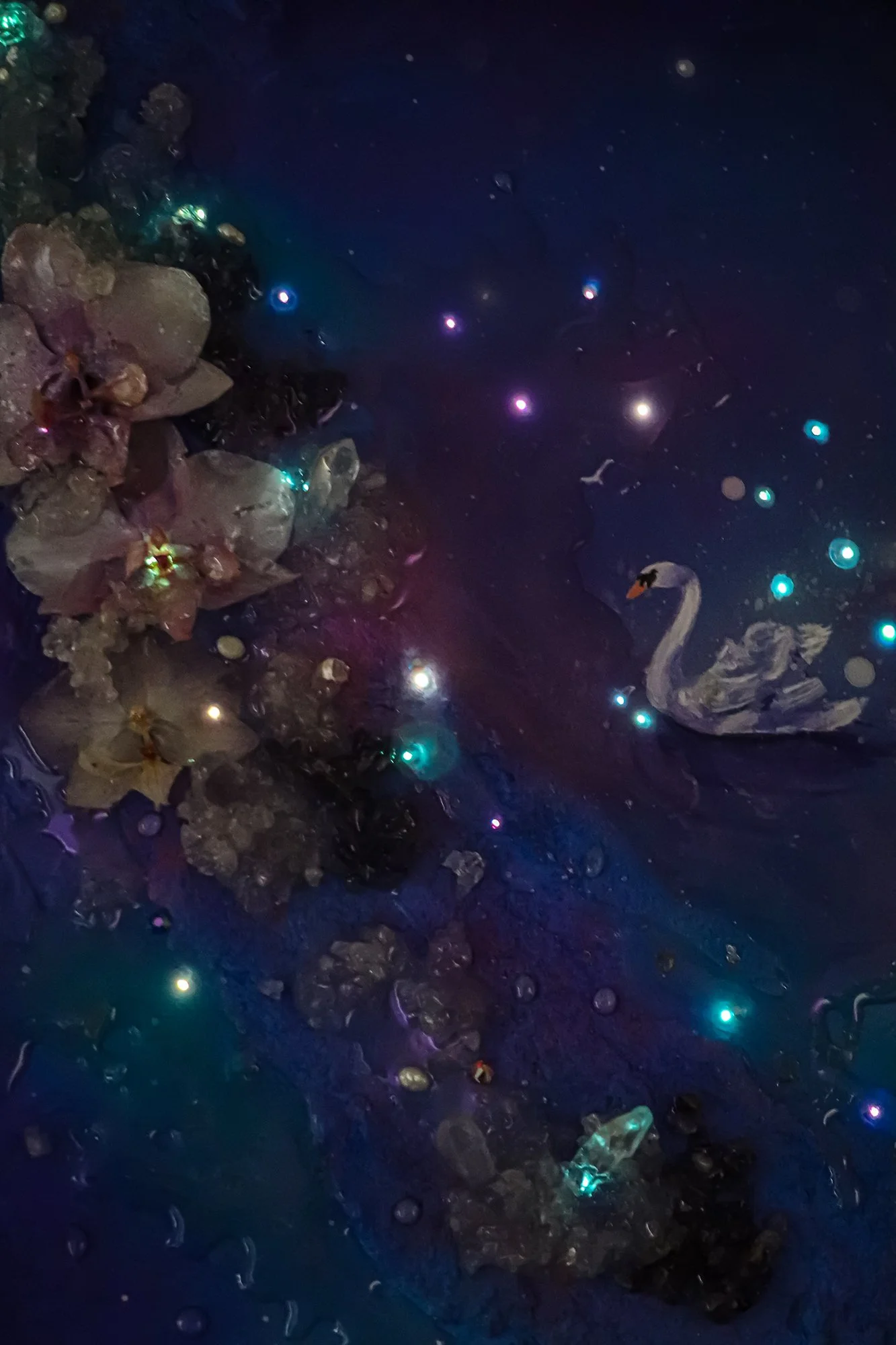 close up detail photo of glowing fiber optics on a swan painting in the dark