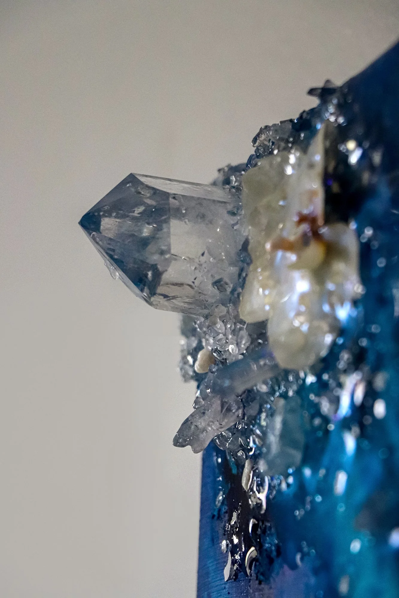 close up detail photo of clear quartz crystal point, on luxury wall art with preserved orchid botanical