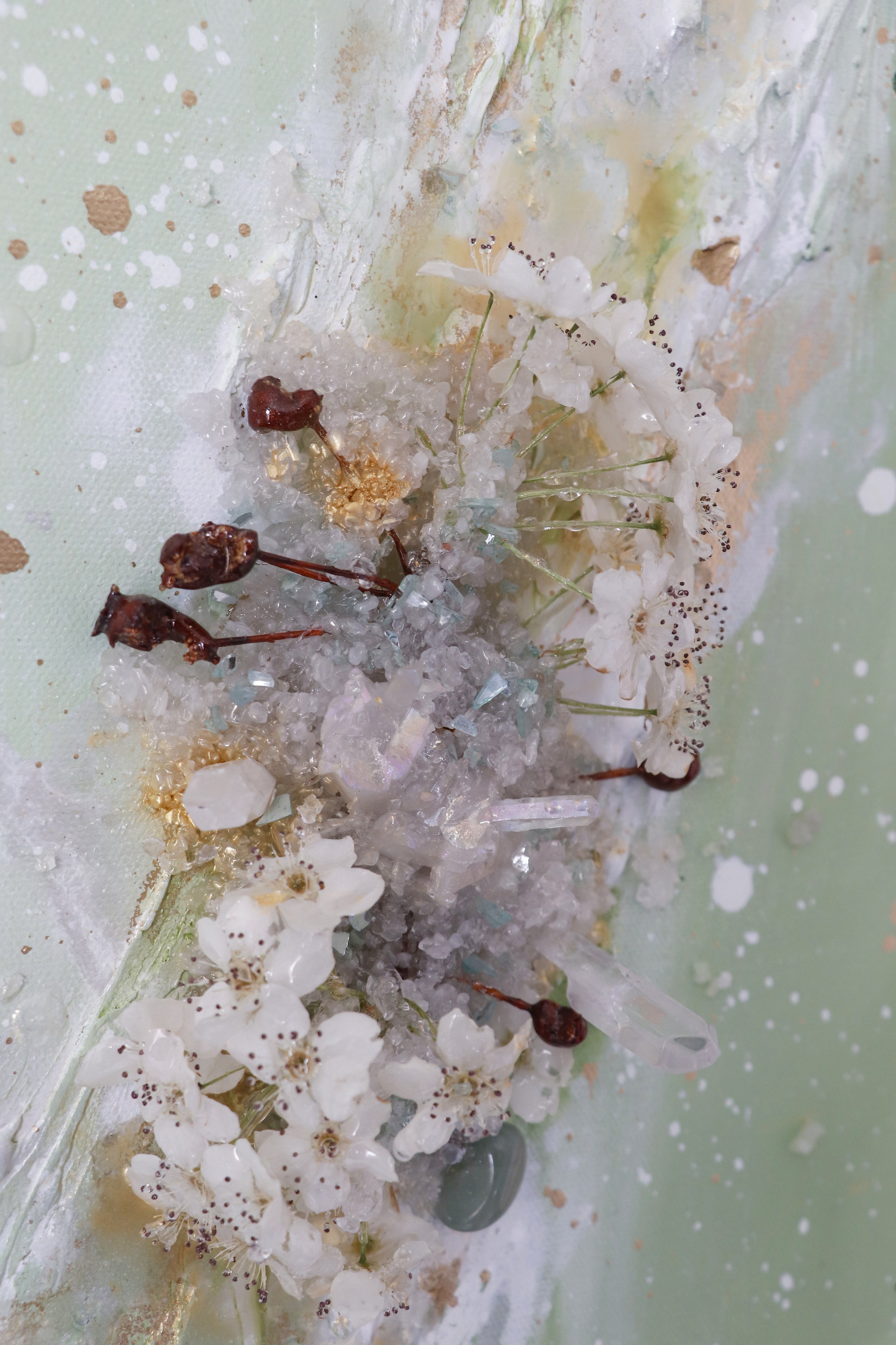 close up detail photo of white preserved pear blossom flower botanicals, with angel aura quartz crystal picked in St George Utah, on abstract painting inspired by spring