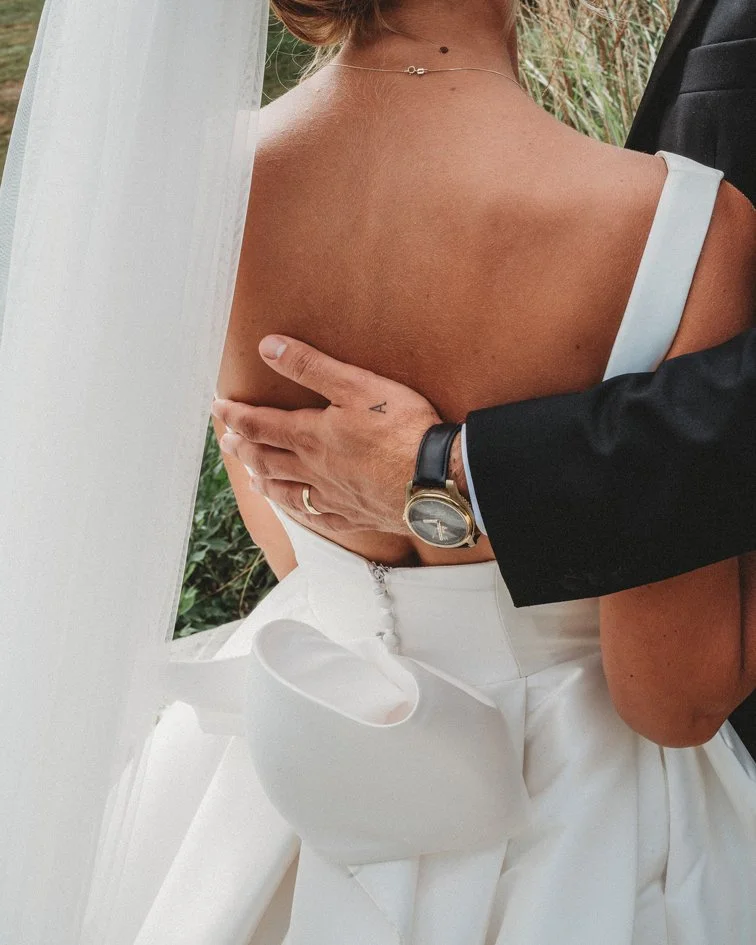 a groom p[laces his hand on his brides back in norwich