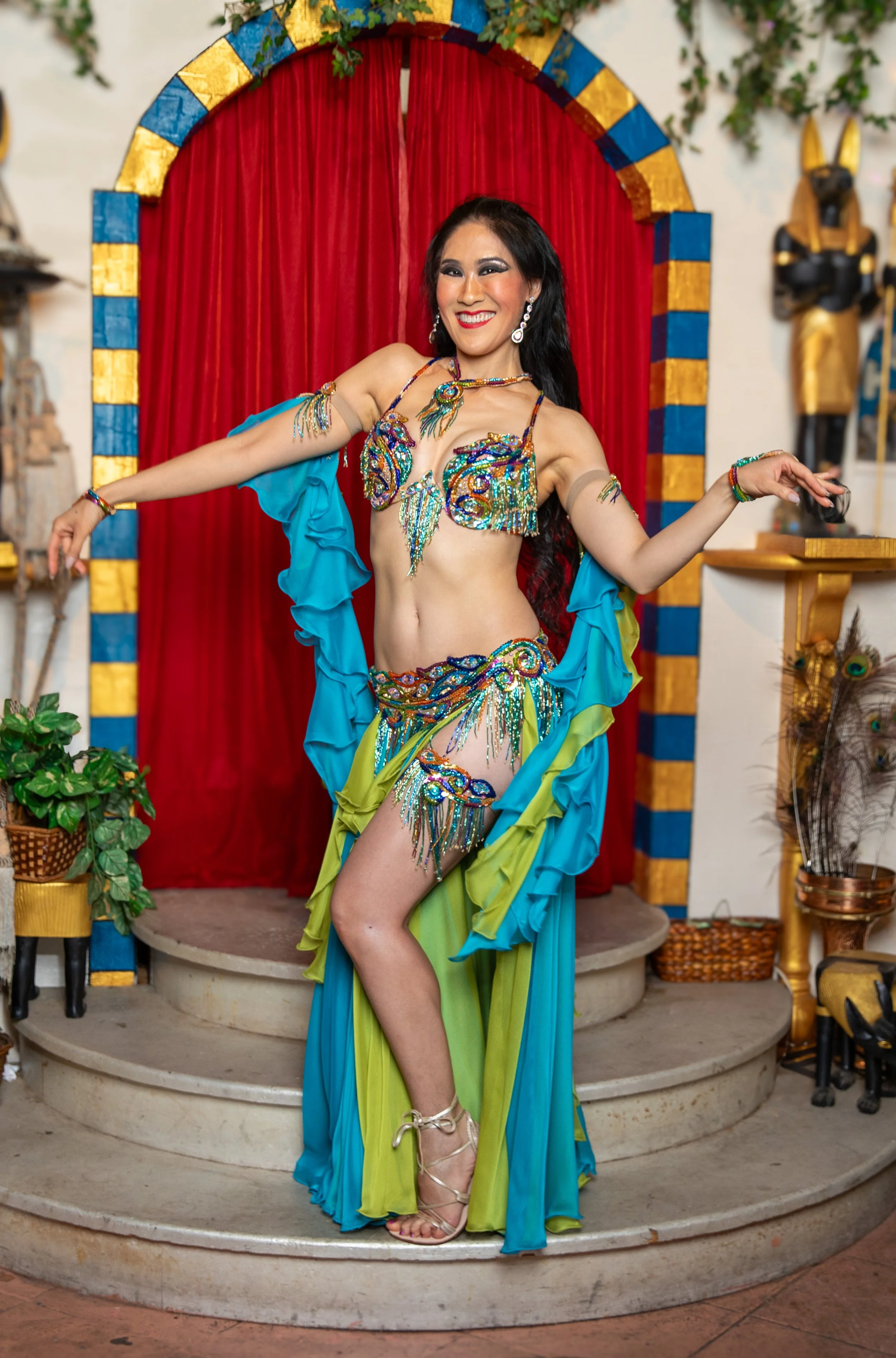 stephaniebellydance.com features Stephanie in San Francisco at Al-Masri restaurant wearing a blue and green costume dancing amid ancient Egyptian decor.