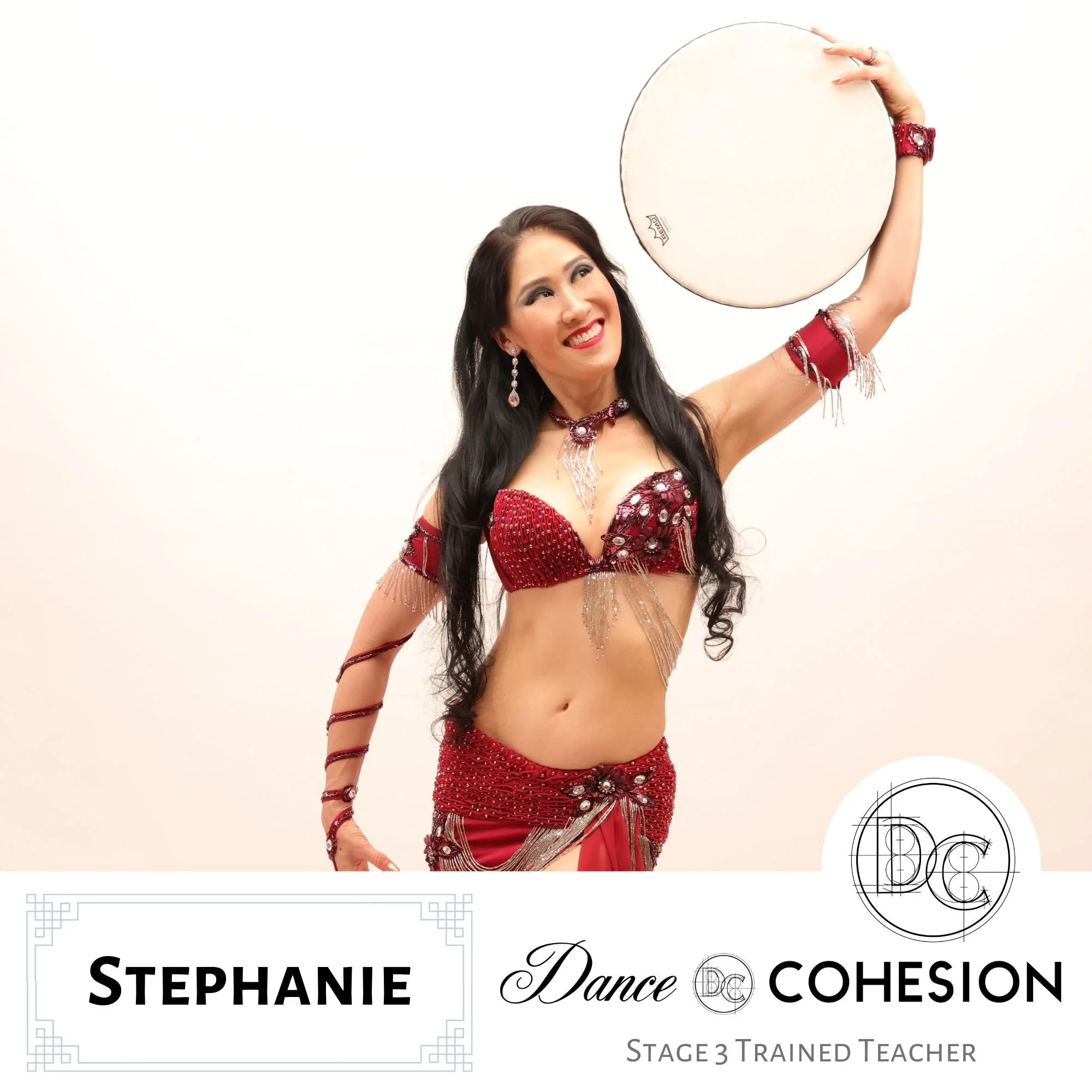 Stephanie in a red dance costume holding a round tambourine. Stephanie has long black hair, wearing jewelry, and the background is cream. The image includes text that says "Stephanie" and promotes Stage 3 Trained Dance Teacher certification.