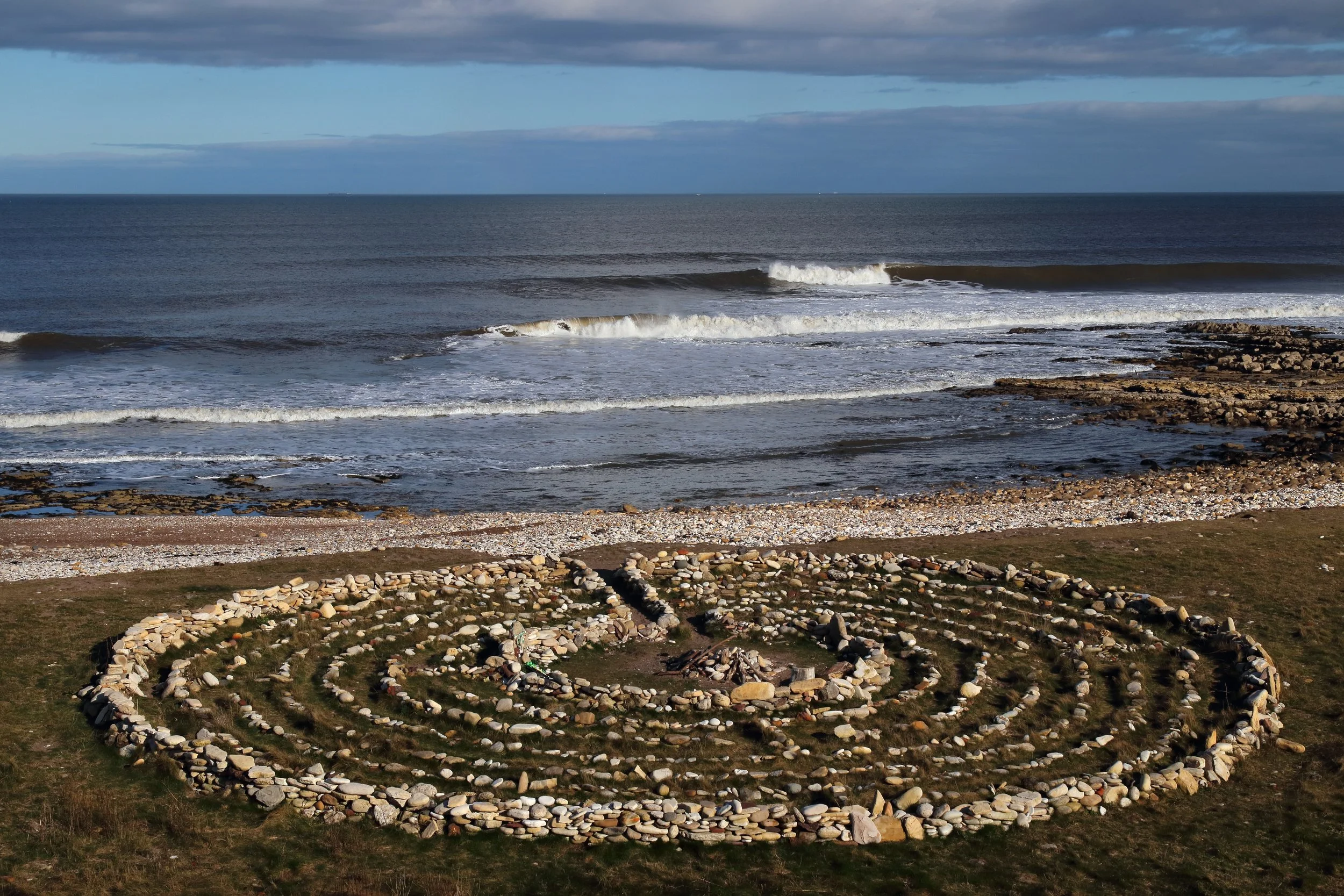 A stone labyrinth beside the sea, representing the path to untangling complex mental health care