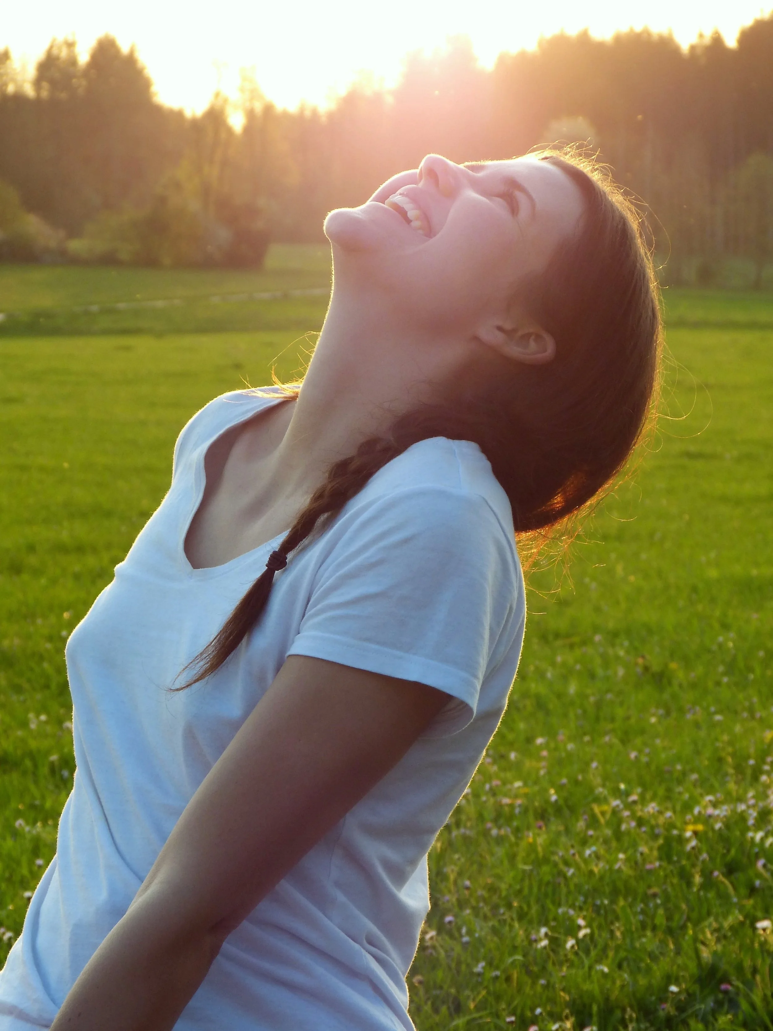 Woman smiling outdoors in a sunlit field, representing relief and focus after integrative ADHD care for adults and perimenopausal women at Sensible Psych Meds in NJ
