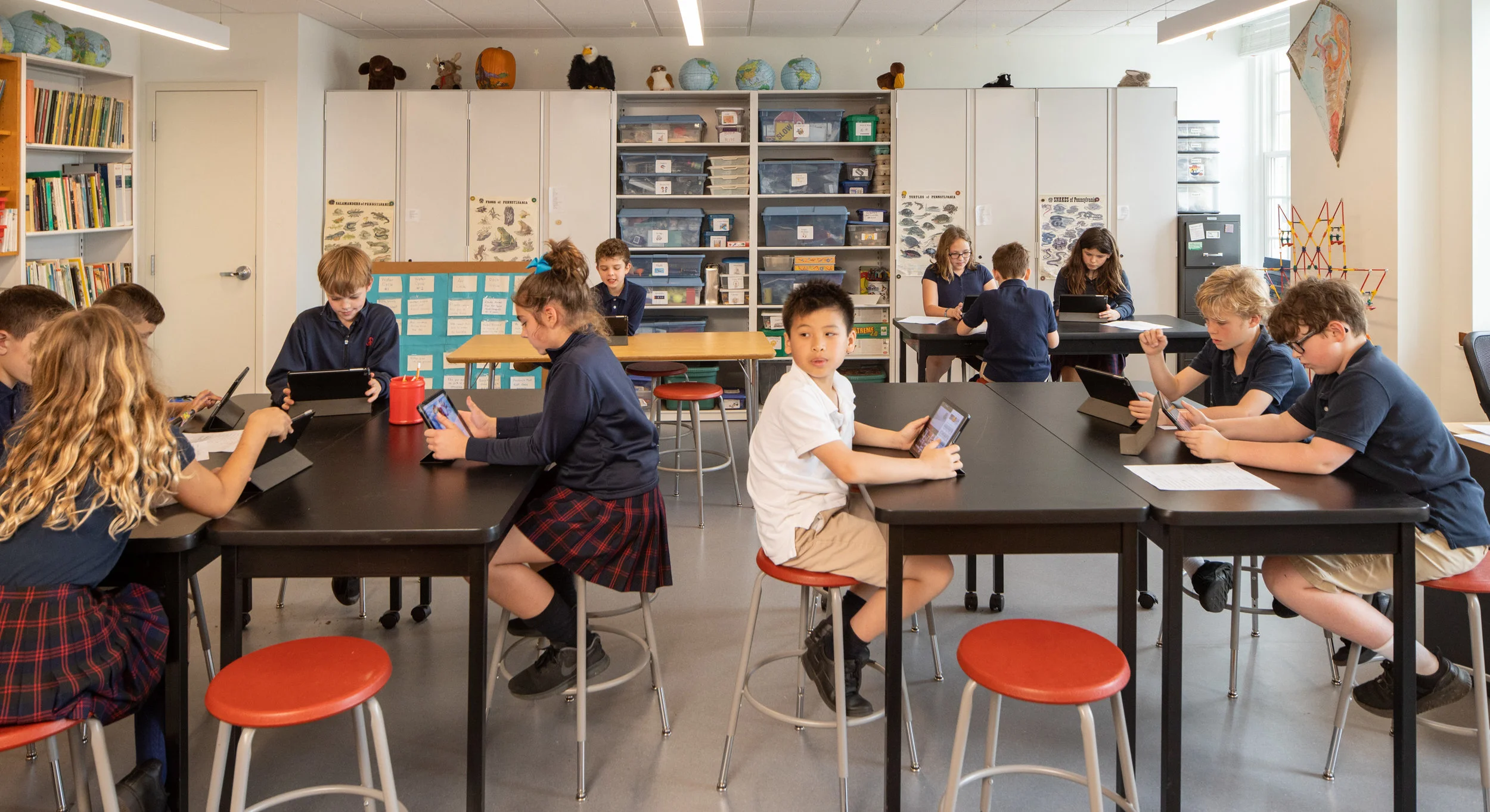 Students work on their iPads to create fact-based videos about planets.