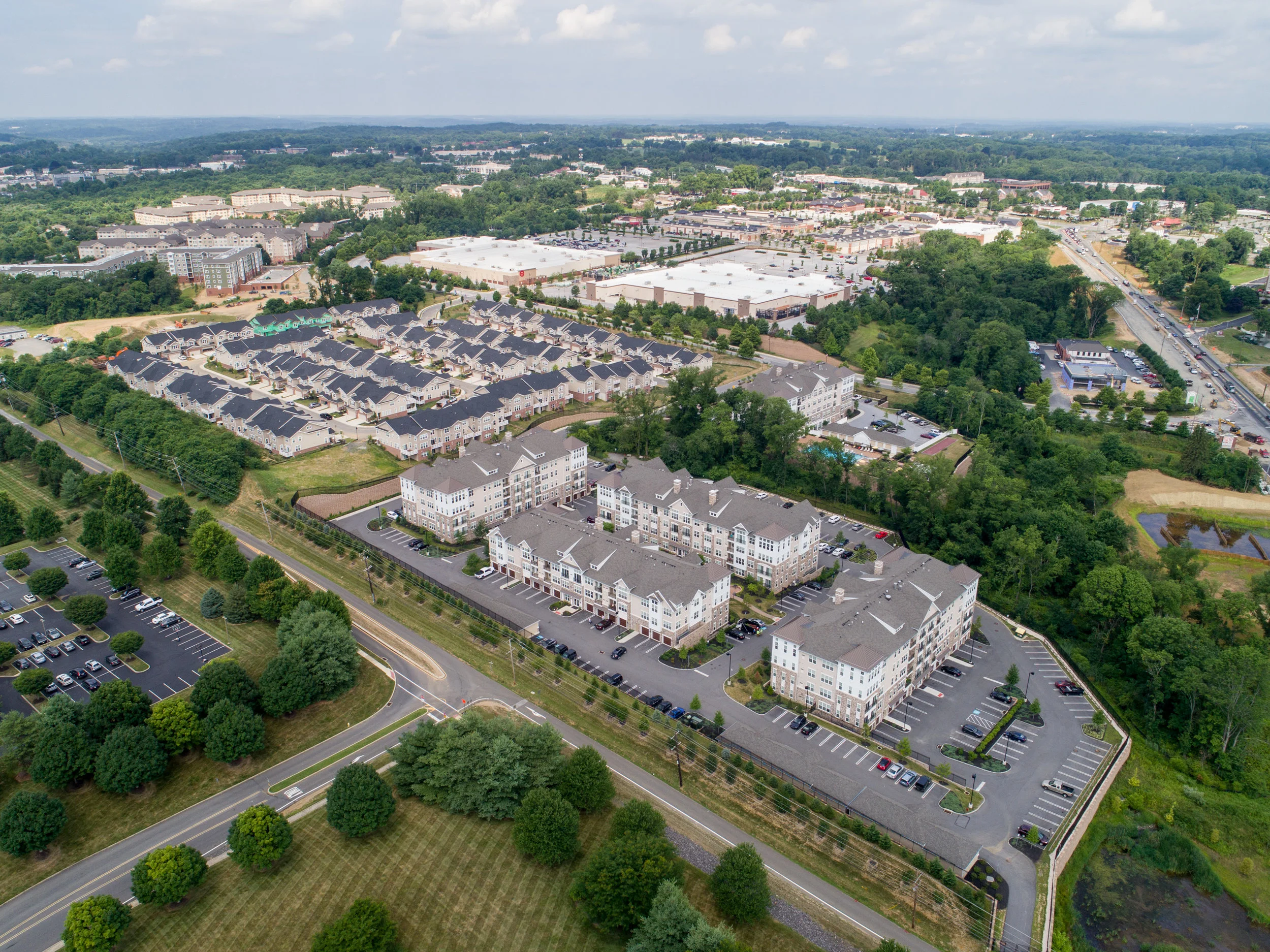 Drone as helicopter – entire apartment complex, with townhouses and retail in the distance.