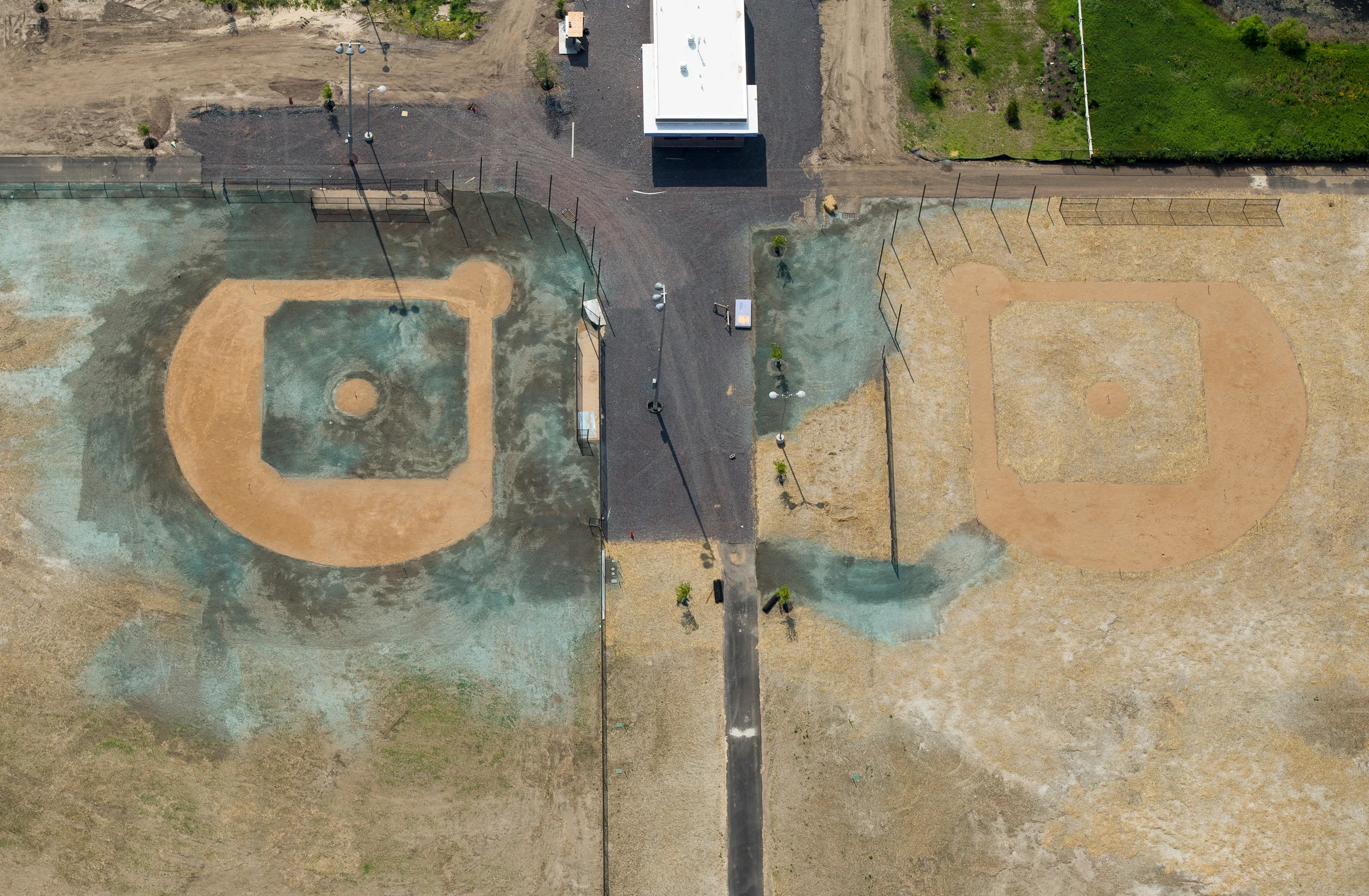 Two fields in Camden, NJ under construction, with new grass seed recently sprayed on the left.