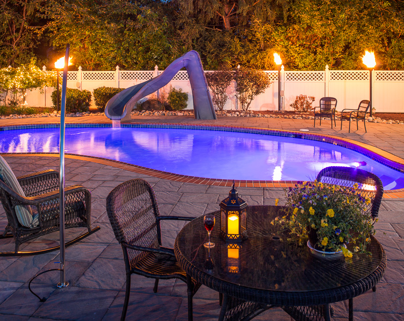 Stunning underwater lights and garden torches light up this party-ready pool.