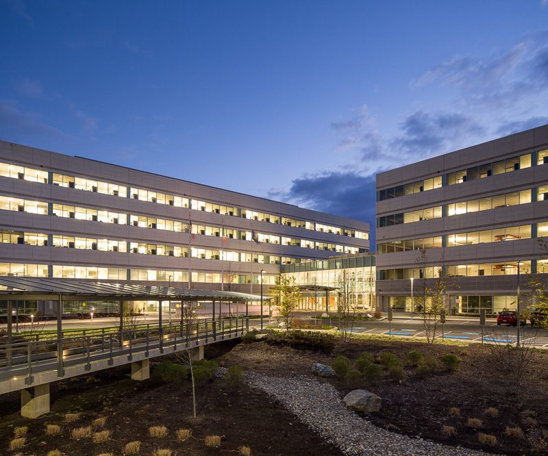 During a fleeting moment, the sun has sunk just low enough for the artificial lights to glow, but not so low as to obscure this exterior covered walkway.