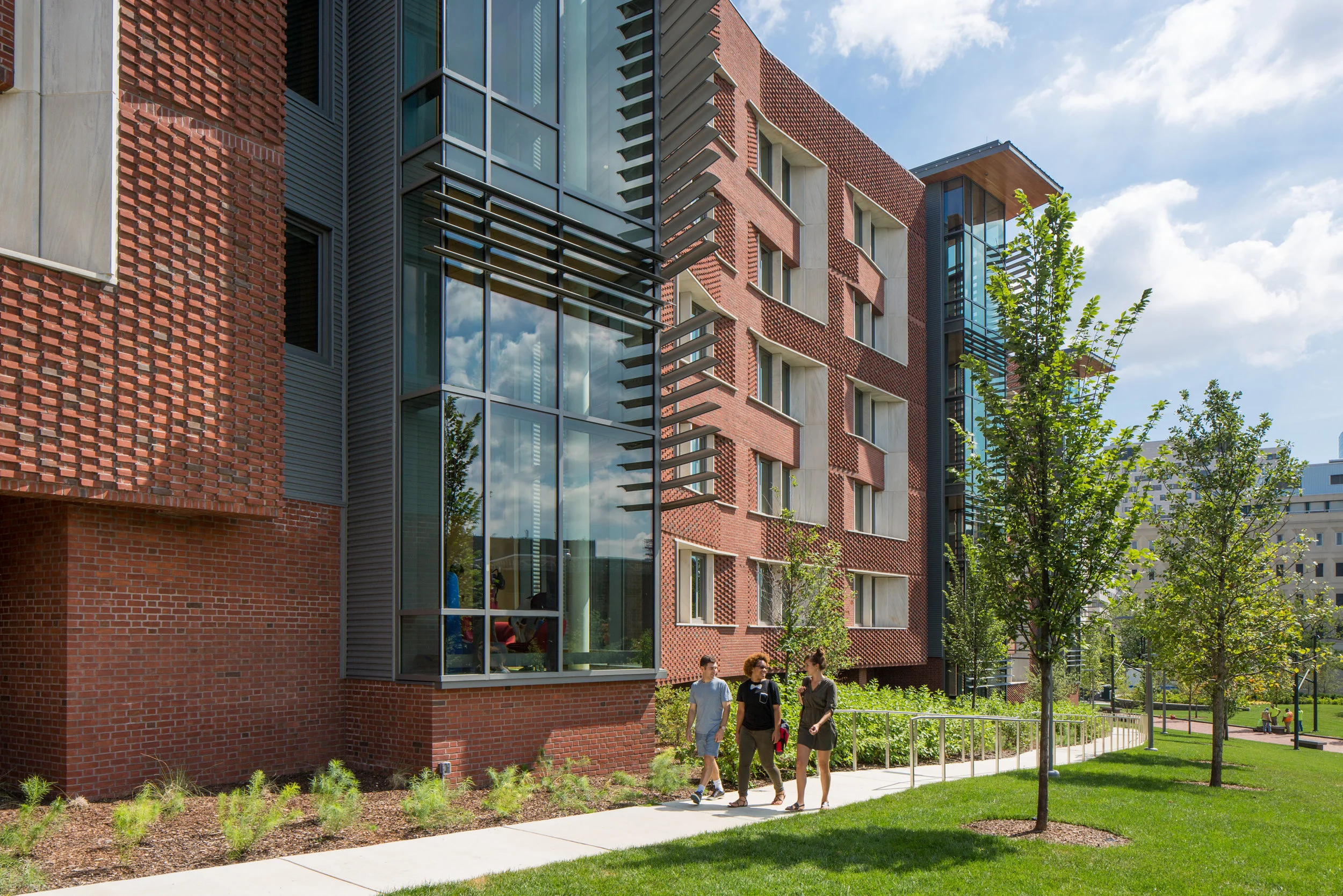 Façades of patterned brick seem to change with the shifting sun; tall glass enclosed areas indicate shared social spaces.