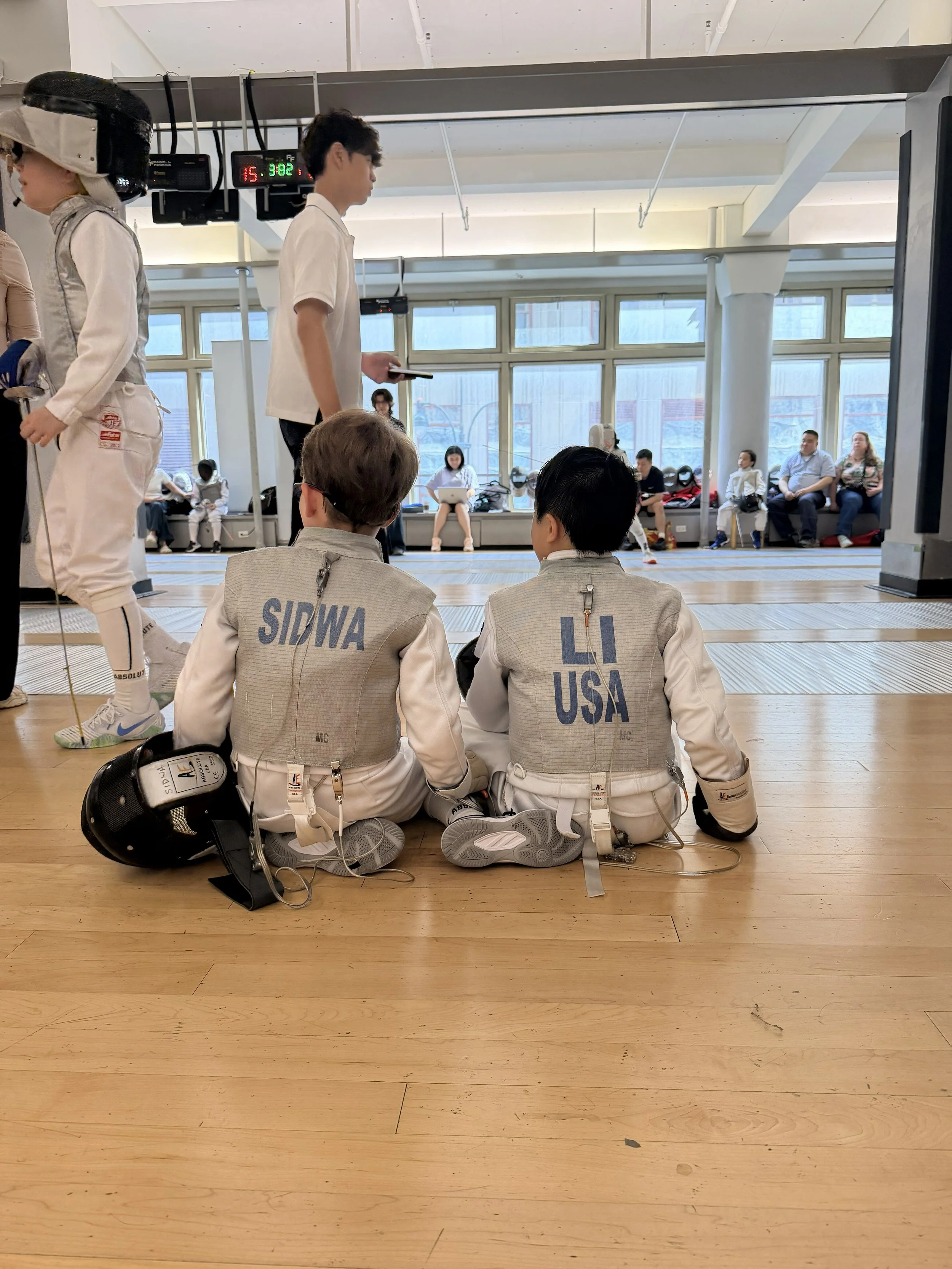 Young child learning how to fence from her coach.
