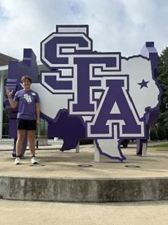 Noah Darnell, recipient of the Brett Cornelius Choral Scholarship, giving the Lumberjack sign at Stephen F. Austin.  Noah will major in Music Education! 