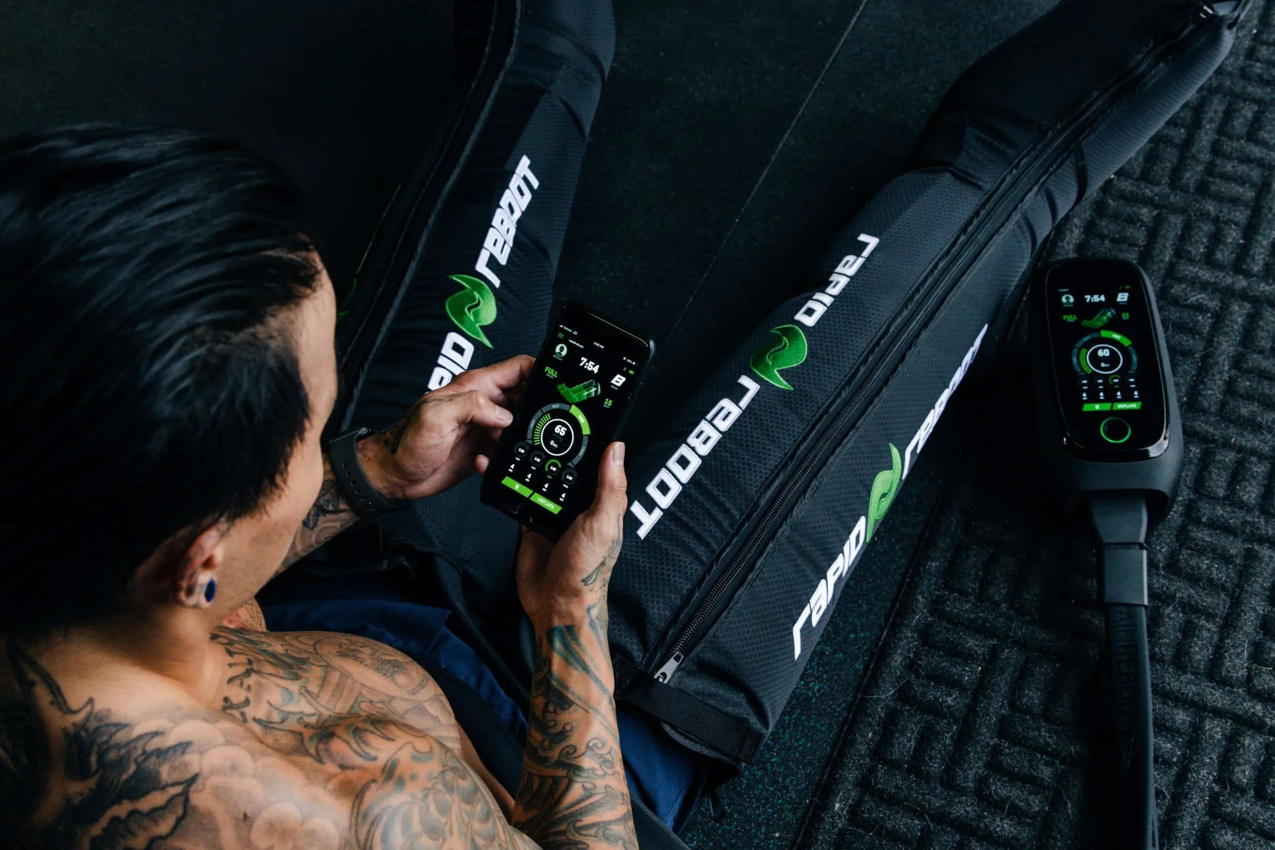 Man using phone to control compression boots for recovery