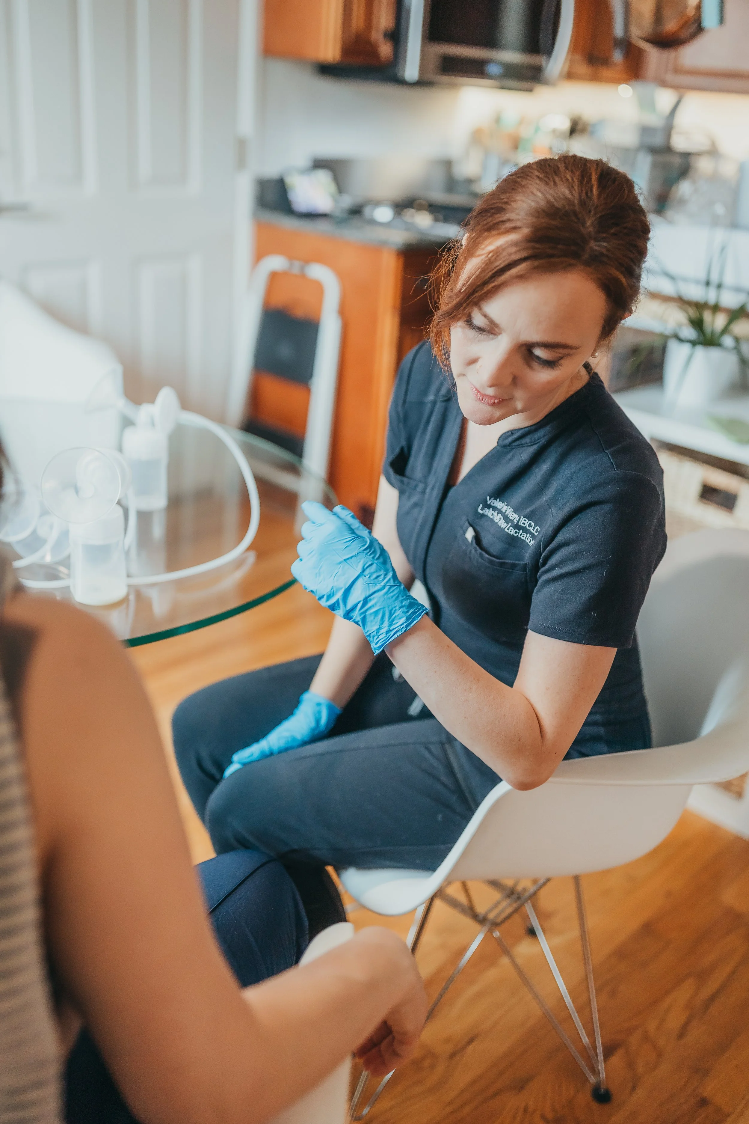 Woman lying on bed, holding and looking at a newborn baby.