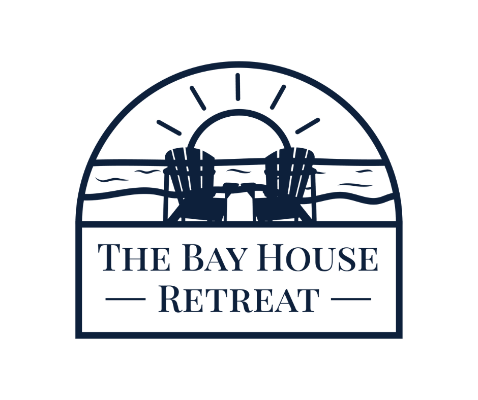 A logo featuring a sunrise over a body of water with two Adirondack chairs facing the water, and the text 'The Bay House Retreat' below.