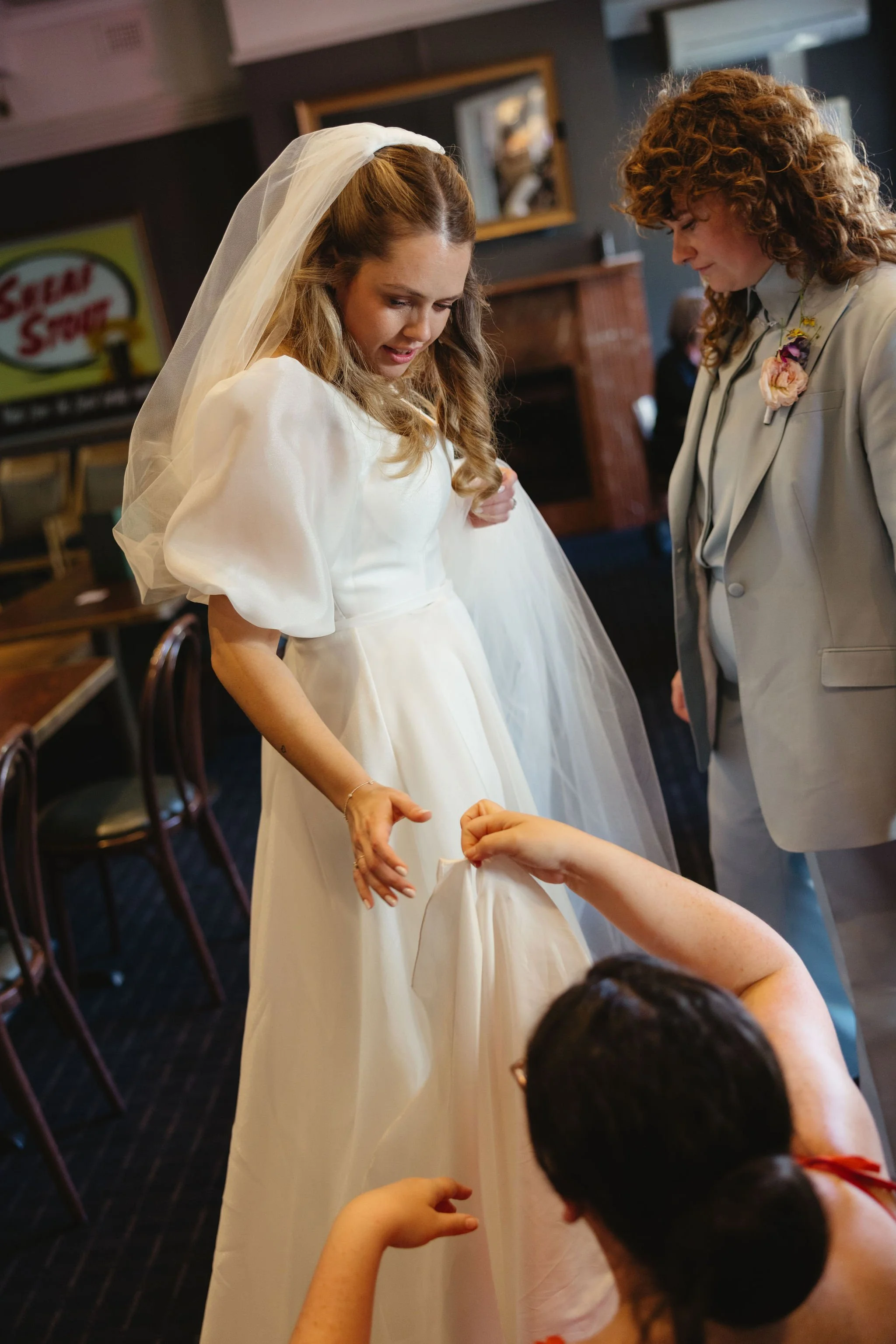 A brides dress being fixed wedding planner 