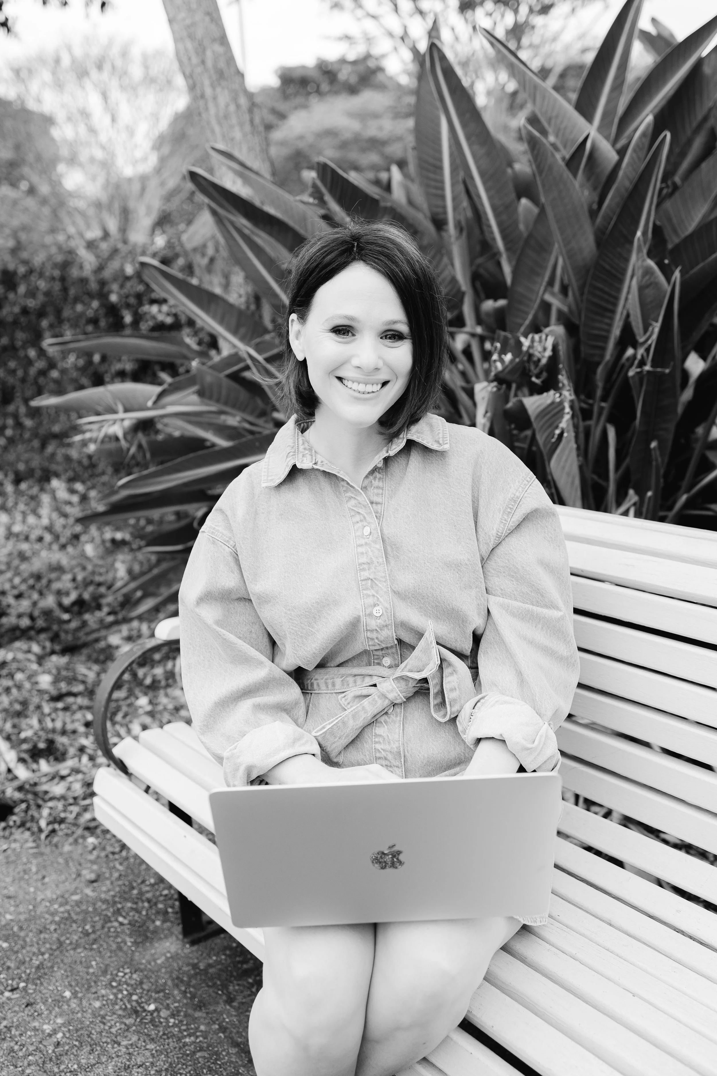 Black and white portrait of a smiling copywriter outdoors.