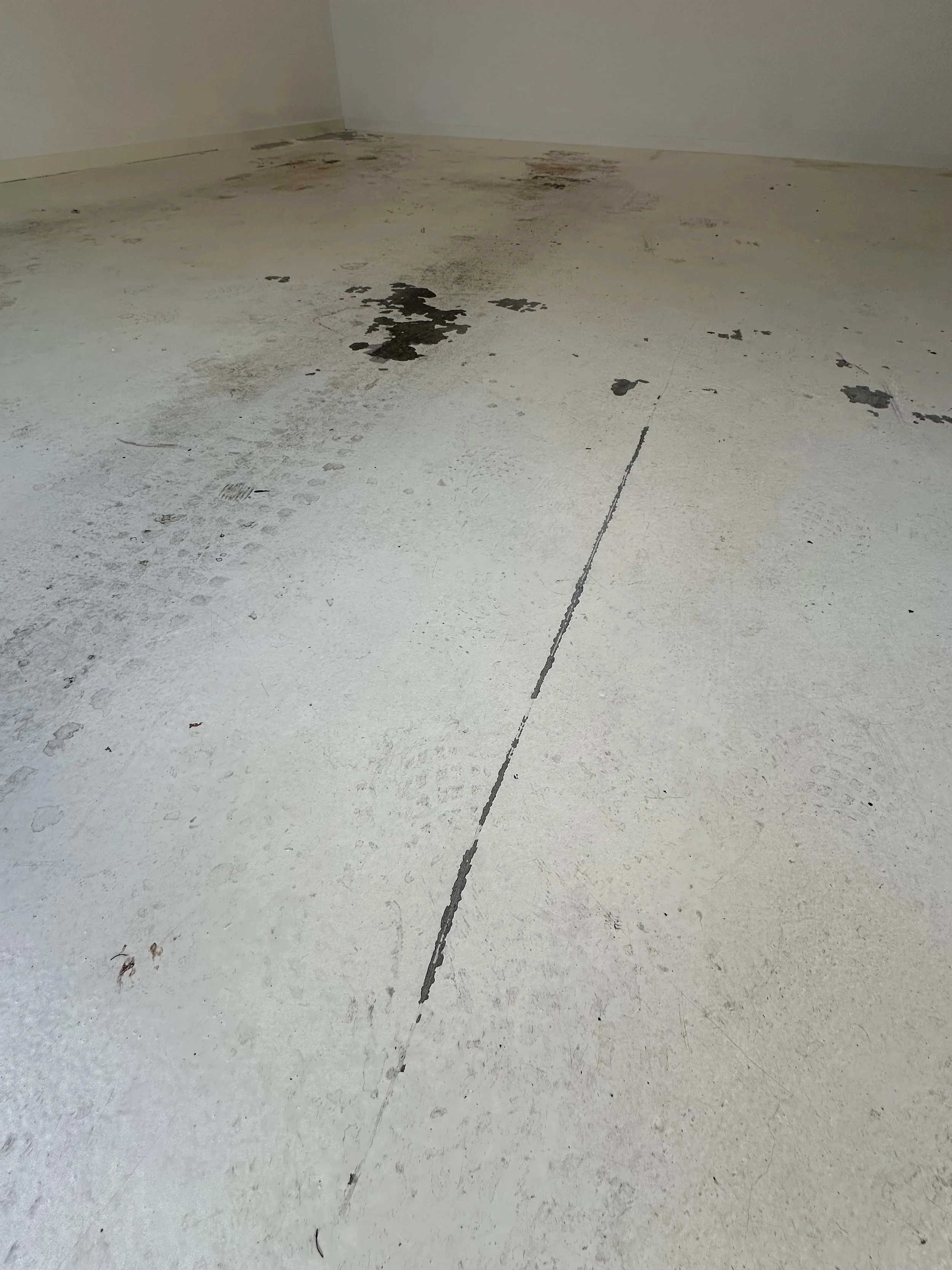 Dirty white floor with black mold and dirt patches