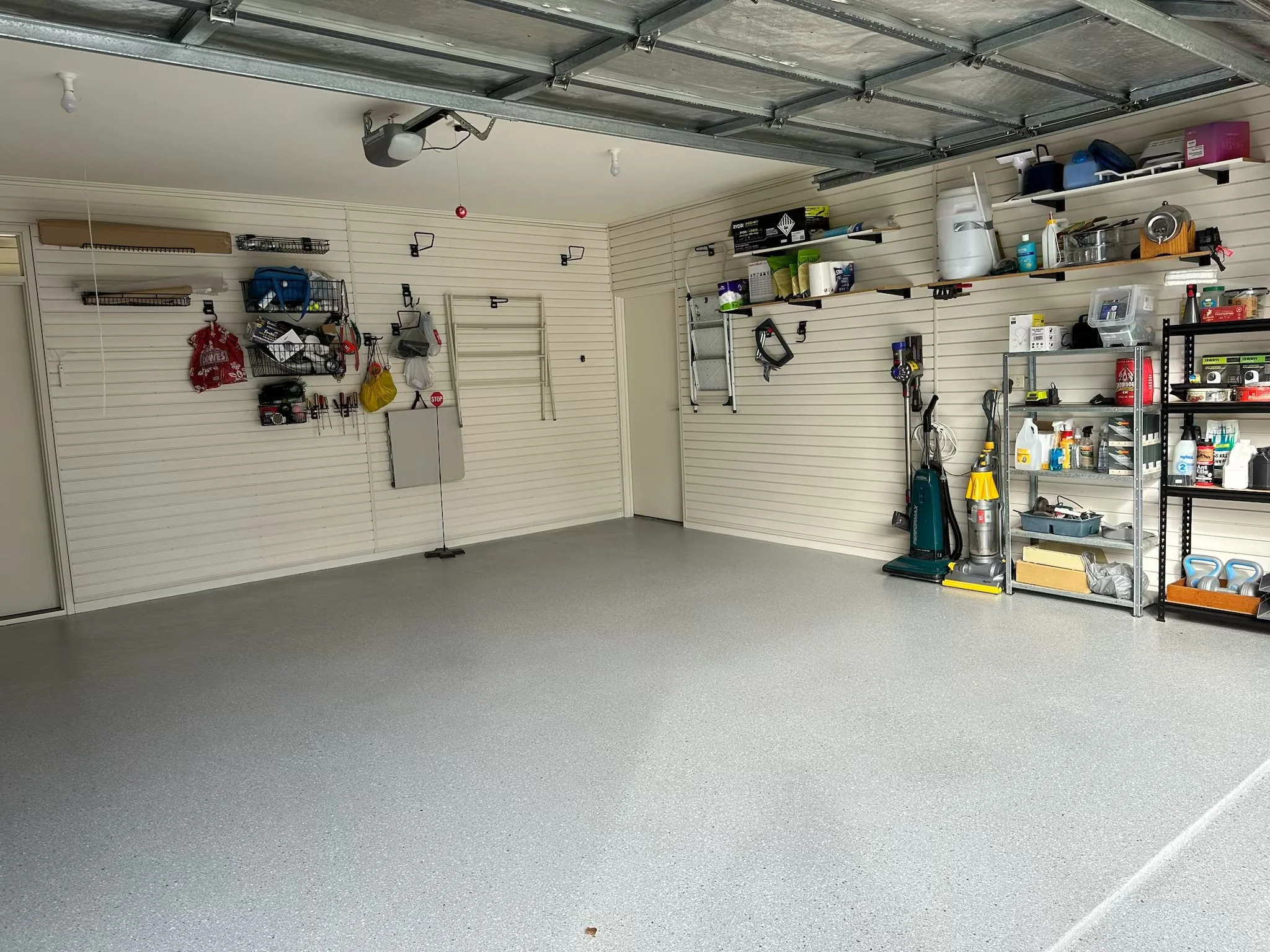 Empty garage with shelves and tools on the walls.