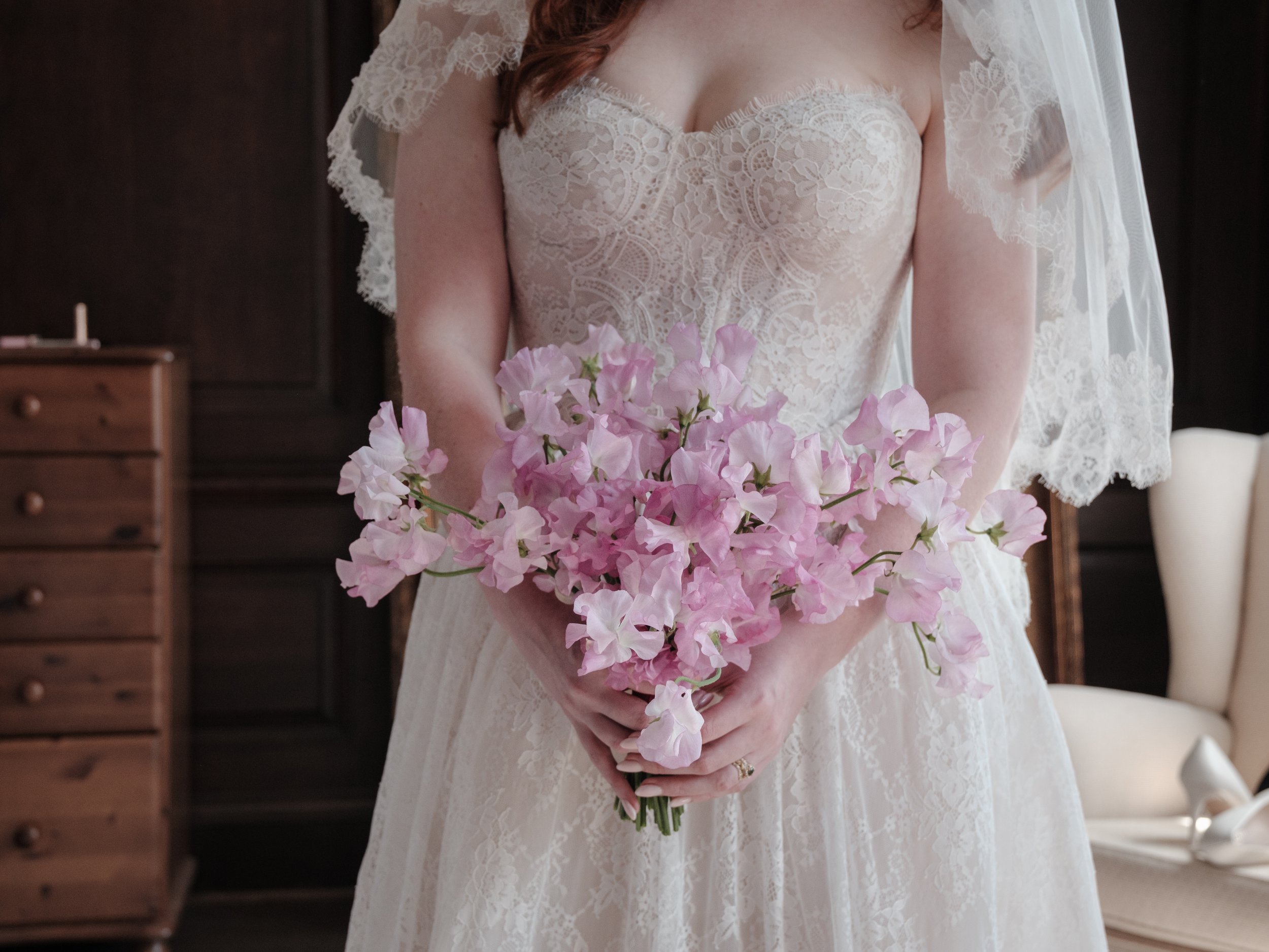 Bride Cloe carries a bridal bouquet made of ruffly pink sweetpeas