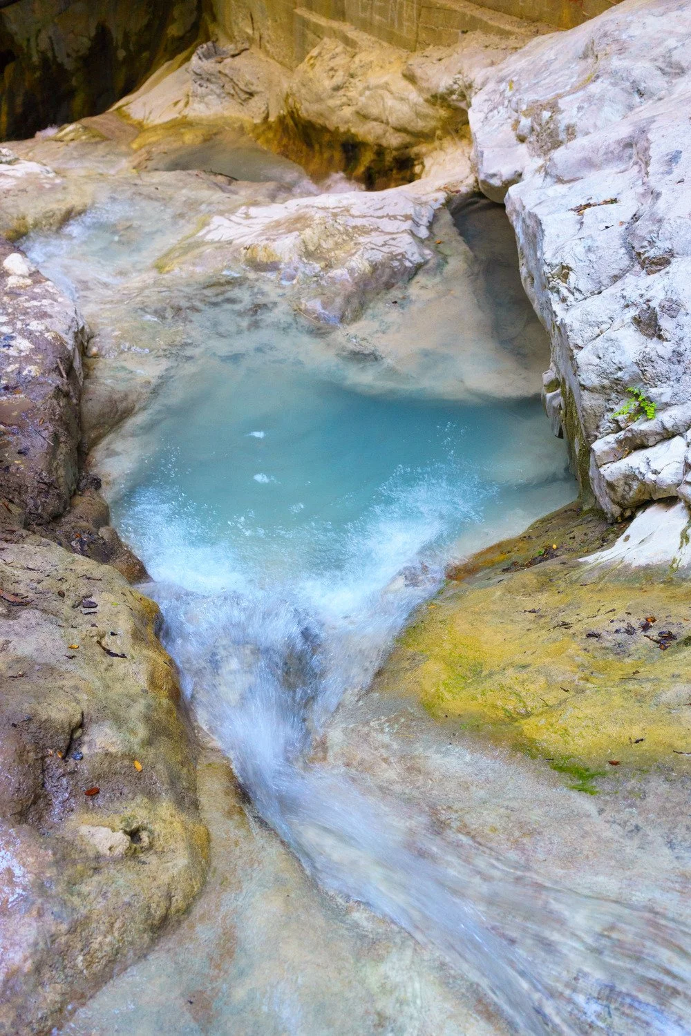 Volcanic spring water flowing over dark stone, naturally rich in minerals, shared by KoKo To Vision Coaching for stress and inflammation support