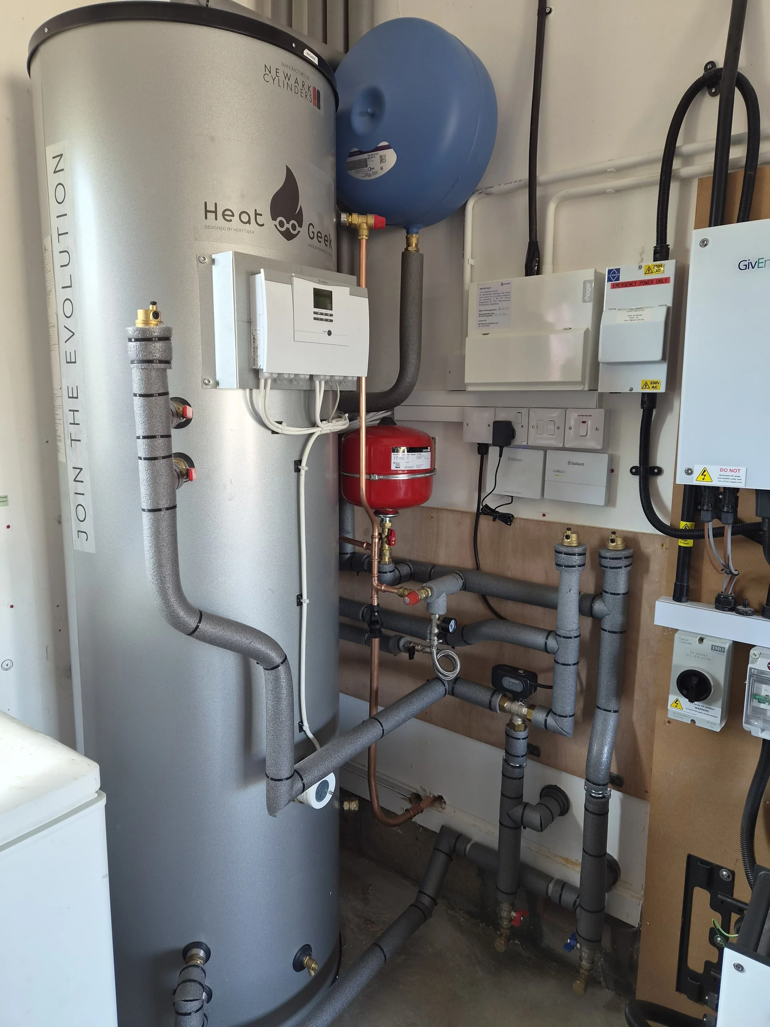 Heat pump cylinder, controls and pipework installed in a utility cupboard