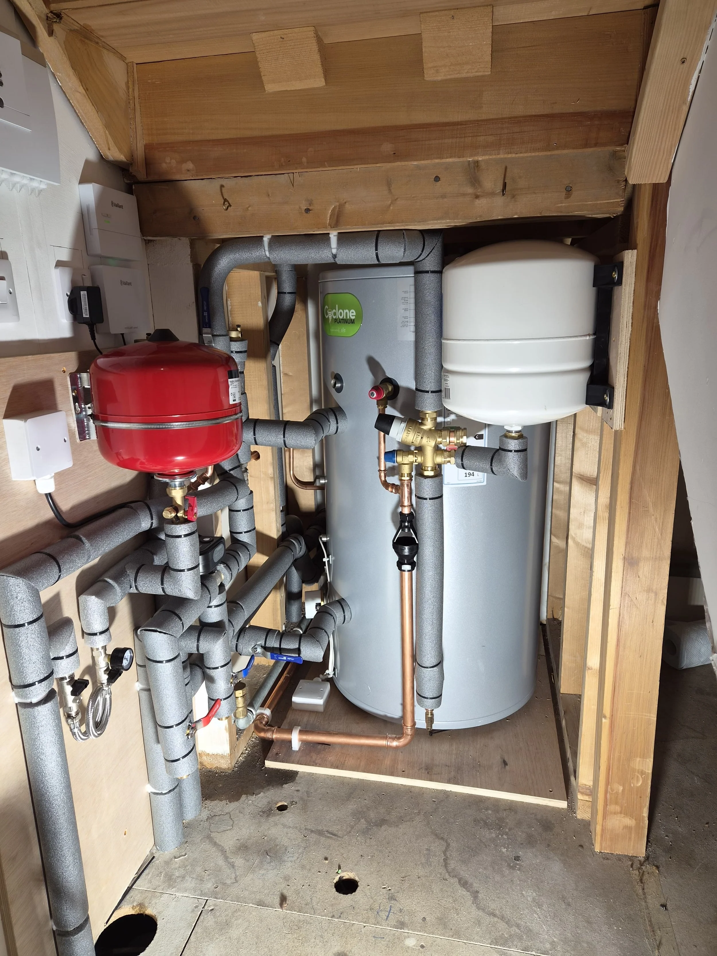 Heat pump plant room with unvented cylinder, expansion vessels and insulated pipework