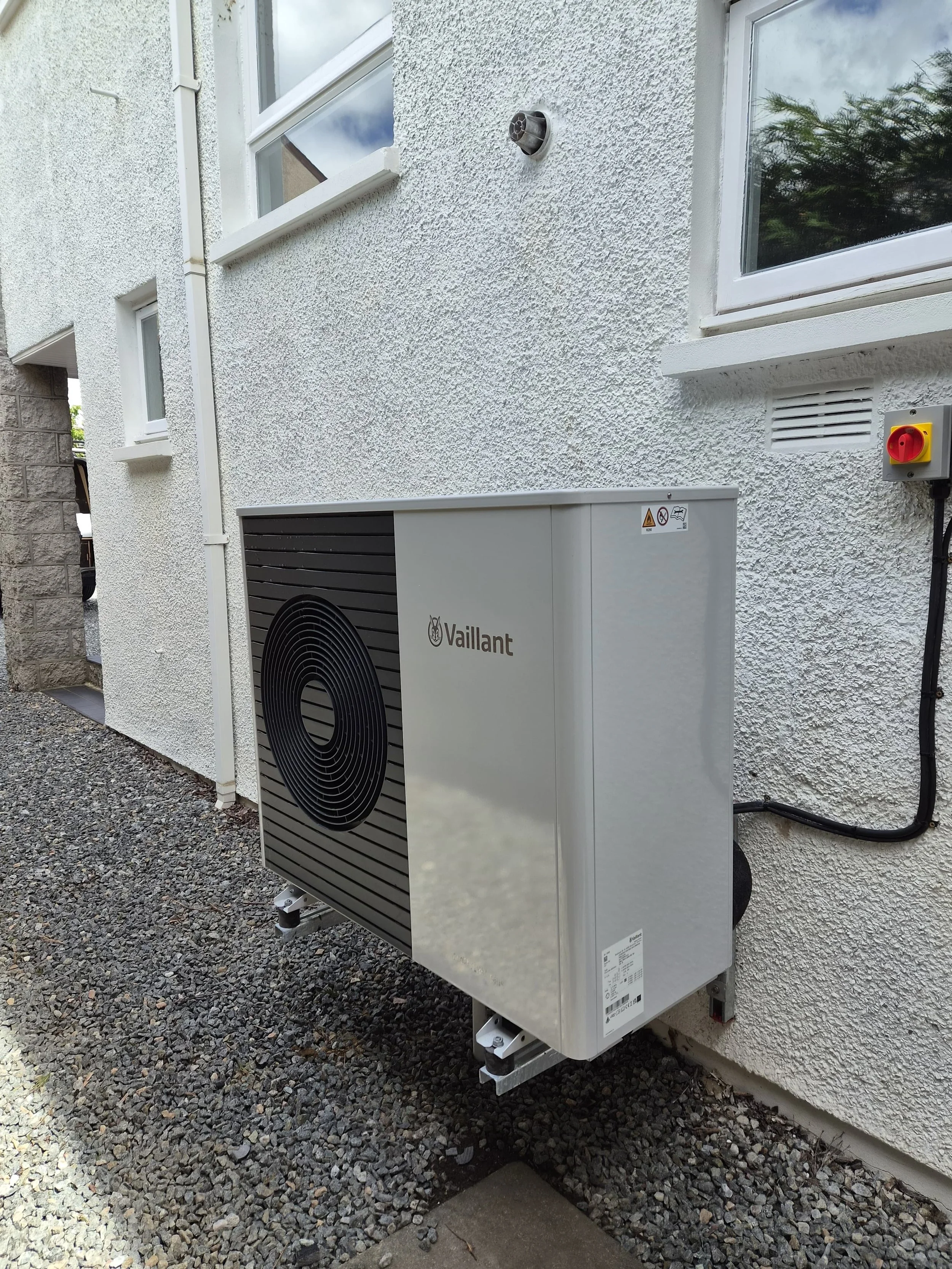 Vaillant air source heat pump outdoor unit mounted against a white rendered wall