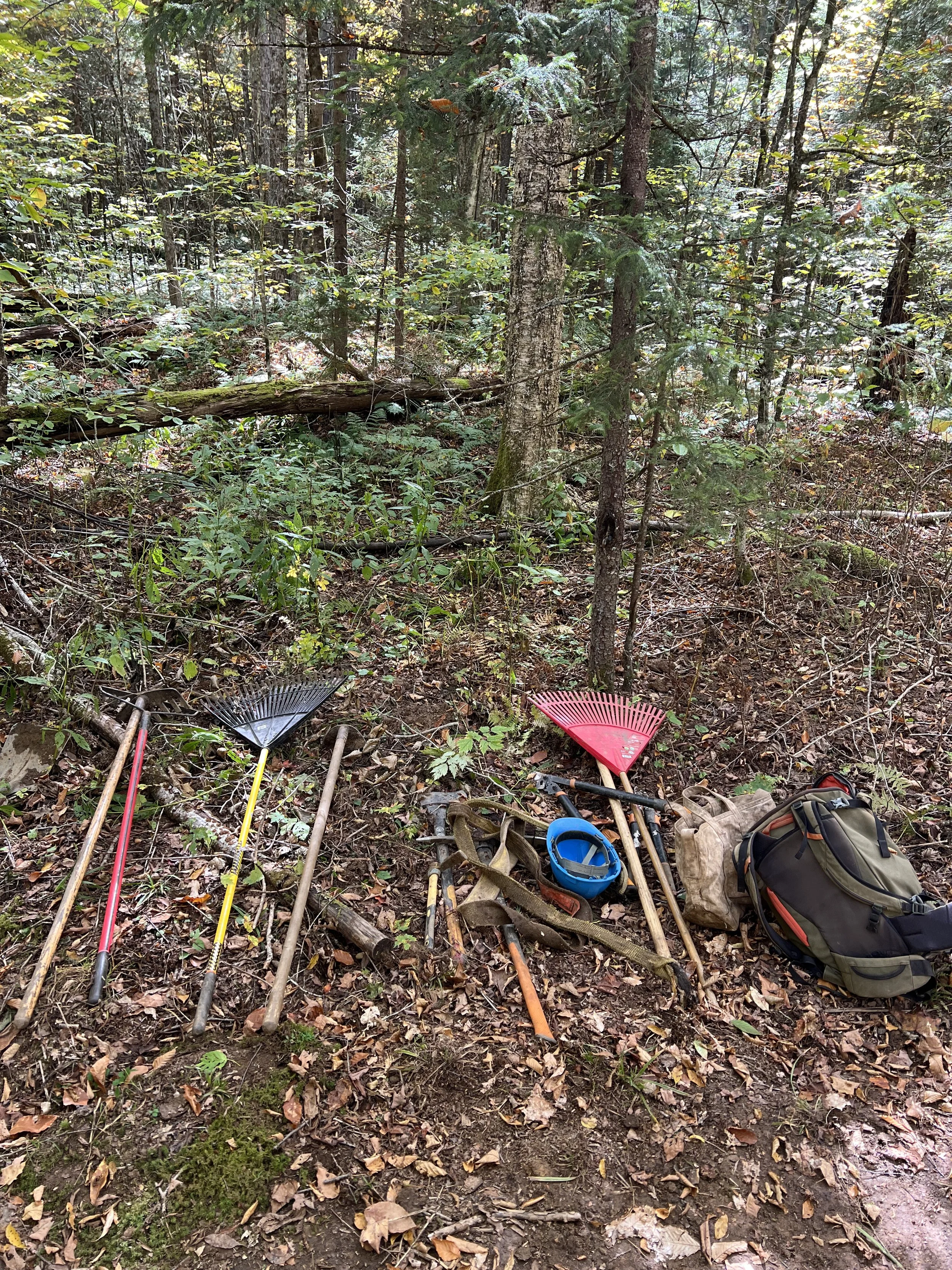 A pile of hand tools stacked along a hillside