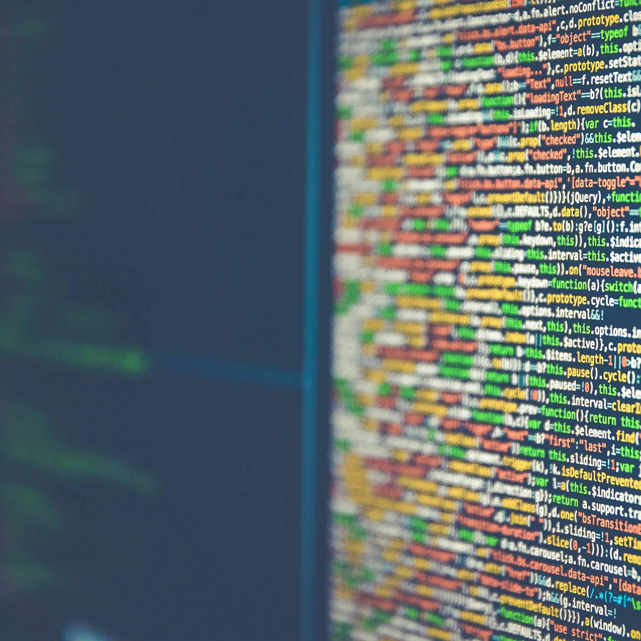 Close-up of a computer screen displaying colorful lines of programming code in a code editor.
