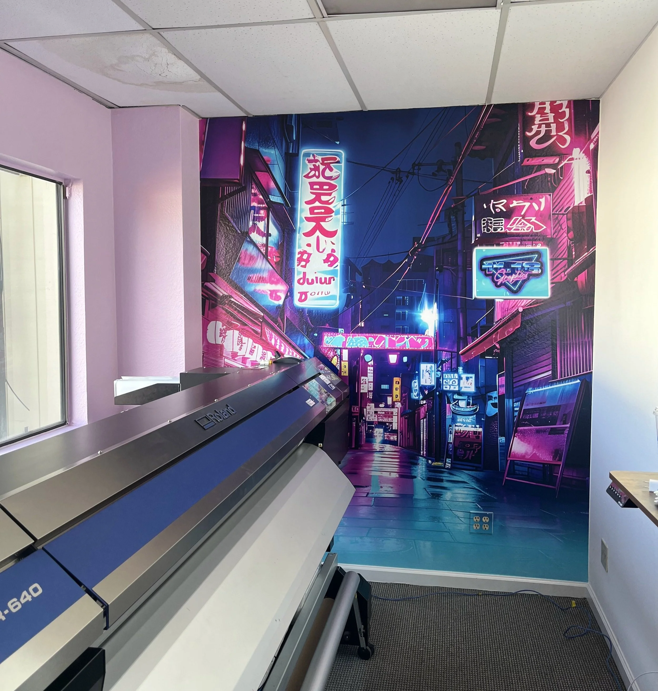 A room with a mural of a neon-lit city street scene on the wall, featuring signs and lights in pink, purple, and blue colors, with a piano and a window on the sides.