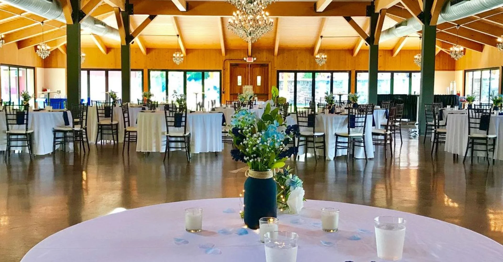 A spacious room arranged with elegant tables and chairs, ready for a beautiful wedding celebration.