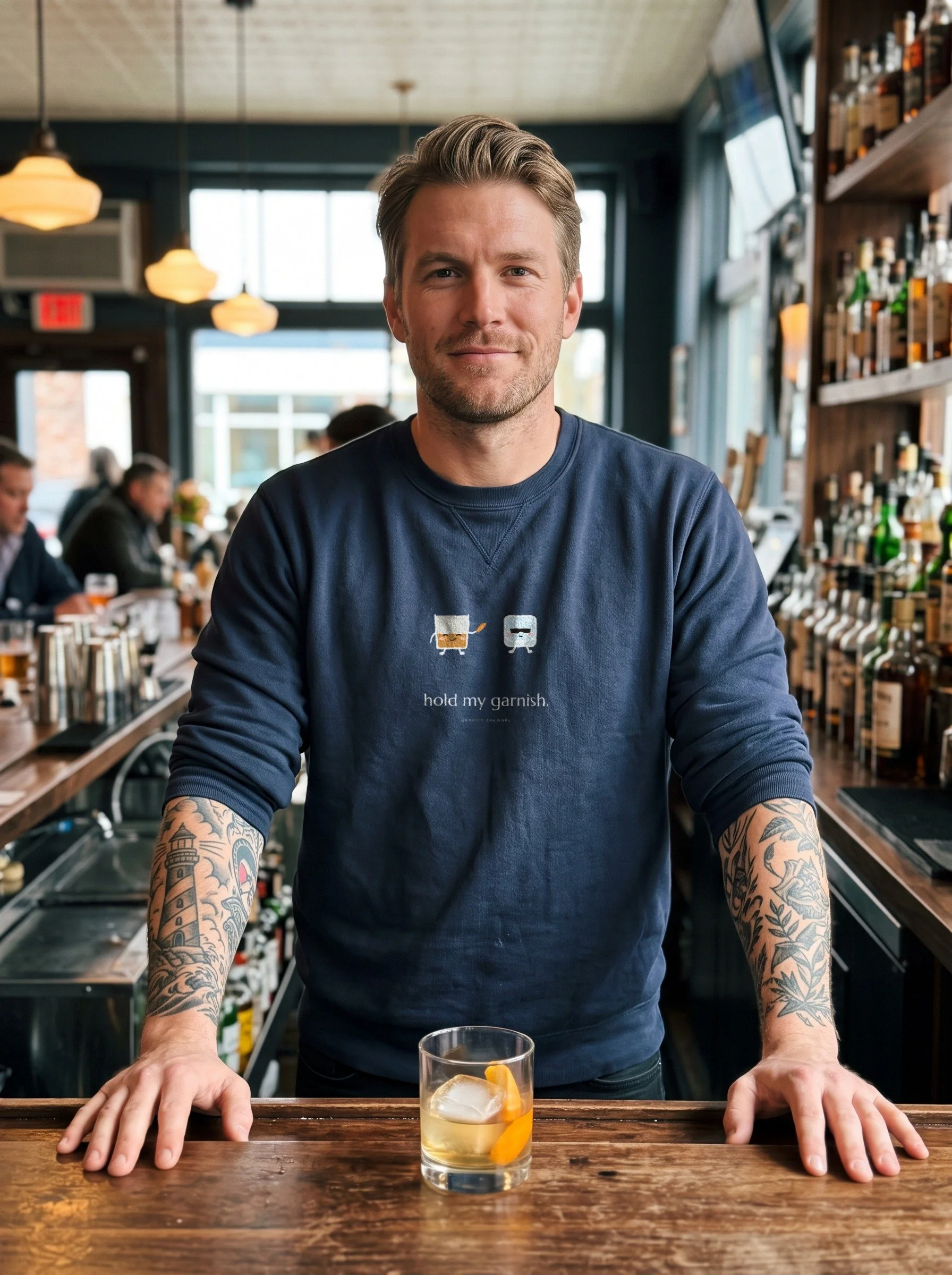 Tattooed bartender in a Navy The Bodyguard crewneck