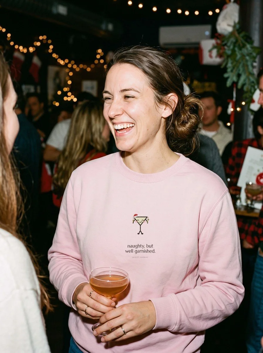 Woman at a holiday bar in a Light Pink Olive Ornaments crewneck