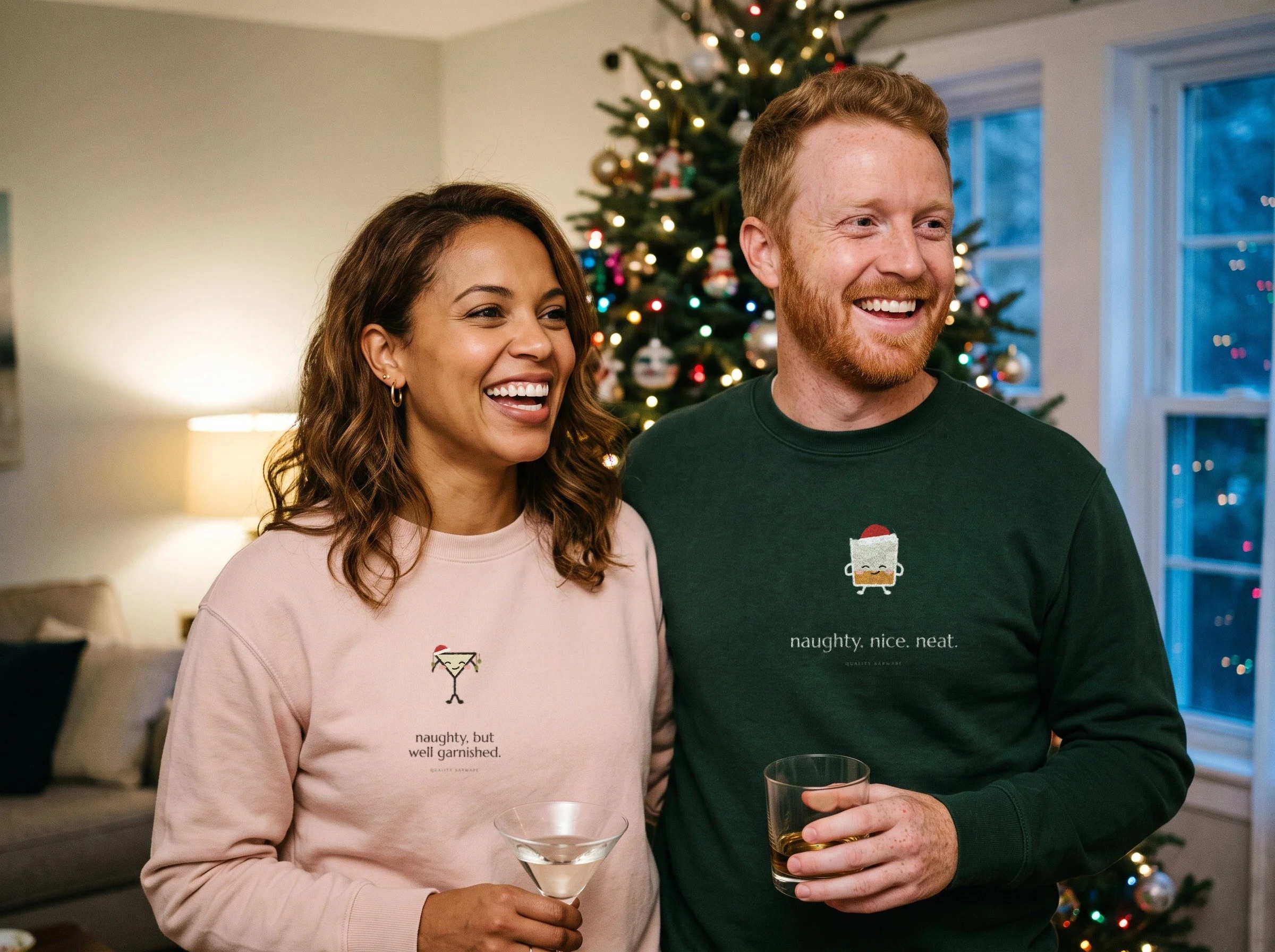 Couple at a holiday party in Lil Pours Olive Ornaments and The Neat List crewnecks